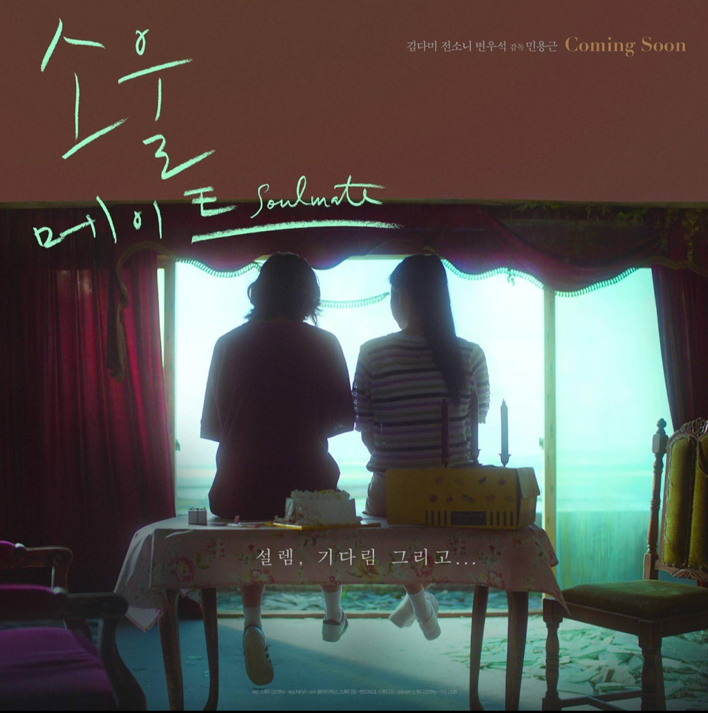 A movie poster showcasing the Korean film entitled Soulmate (2023). Two girls sit side by side on a table in what looks like a dark room. Their backs are to us, and in front of them, there is an open gap in the wall that opens to the ocean.