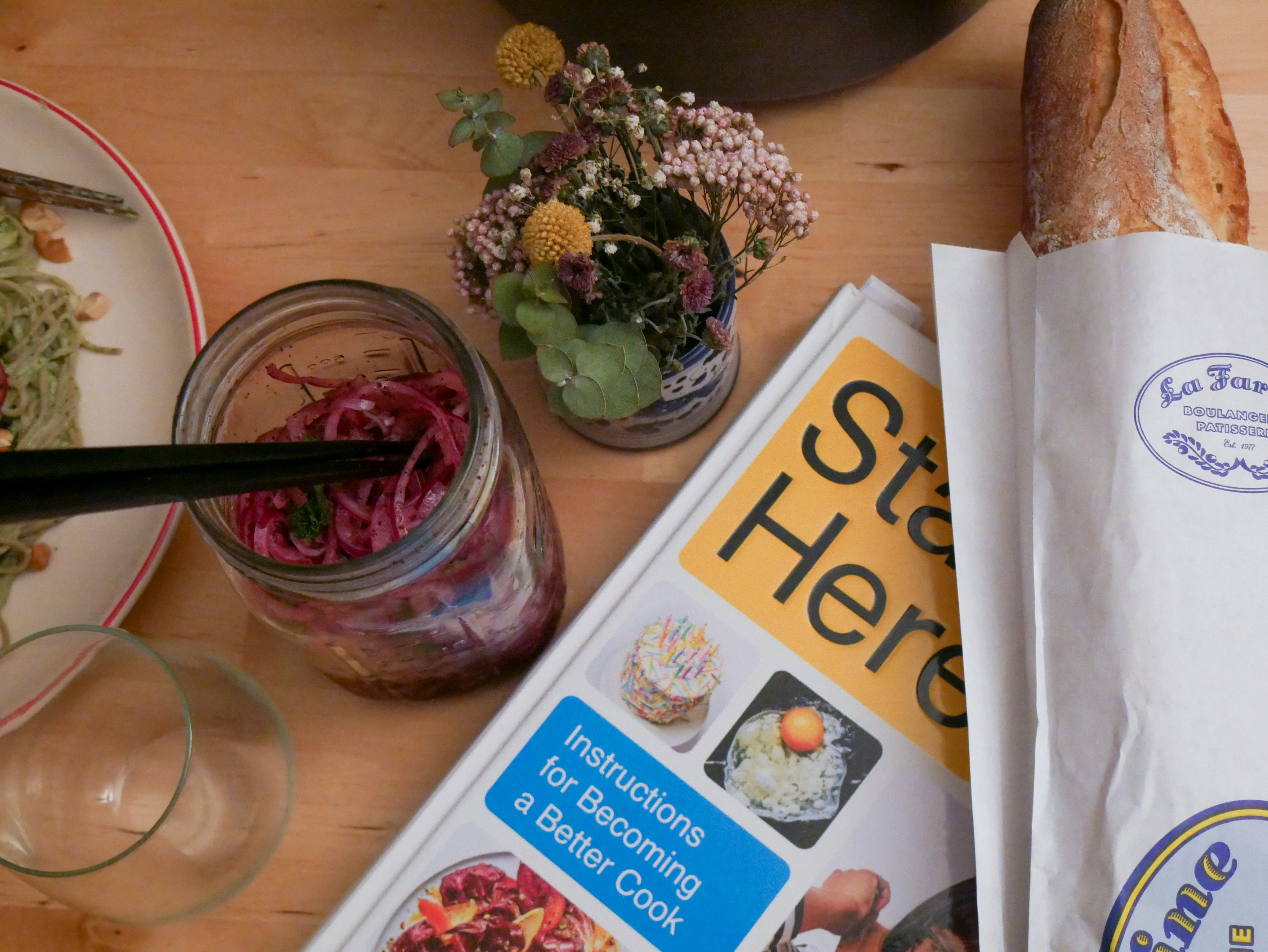 Book, bread, onions and flowers in an overhead shot