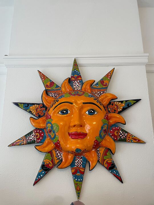 colorful orange ceramic sun interior decor on wall