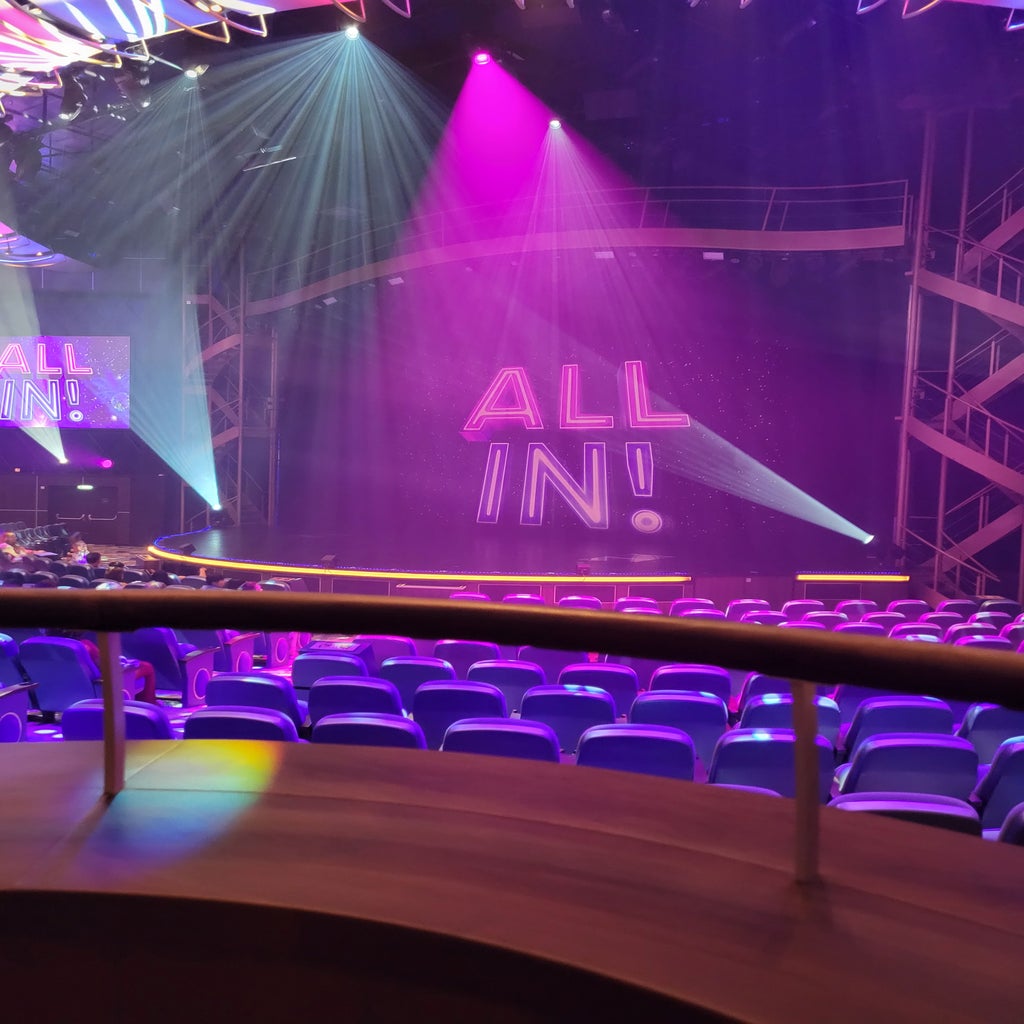 A balcony seat viewing of an emoty stage with the show title of \