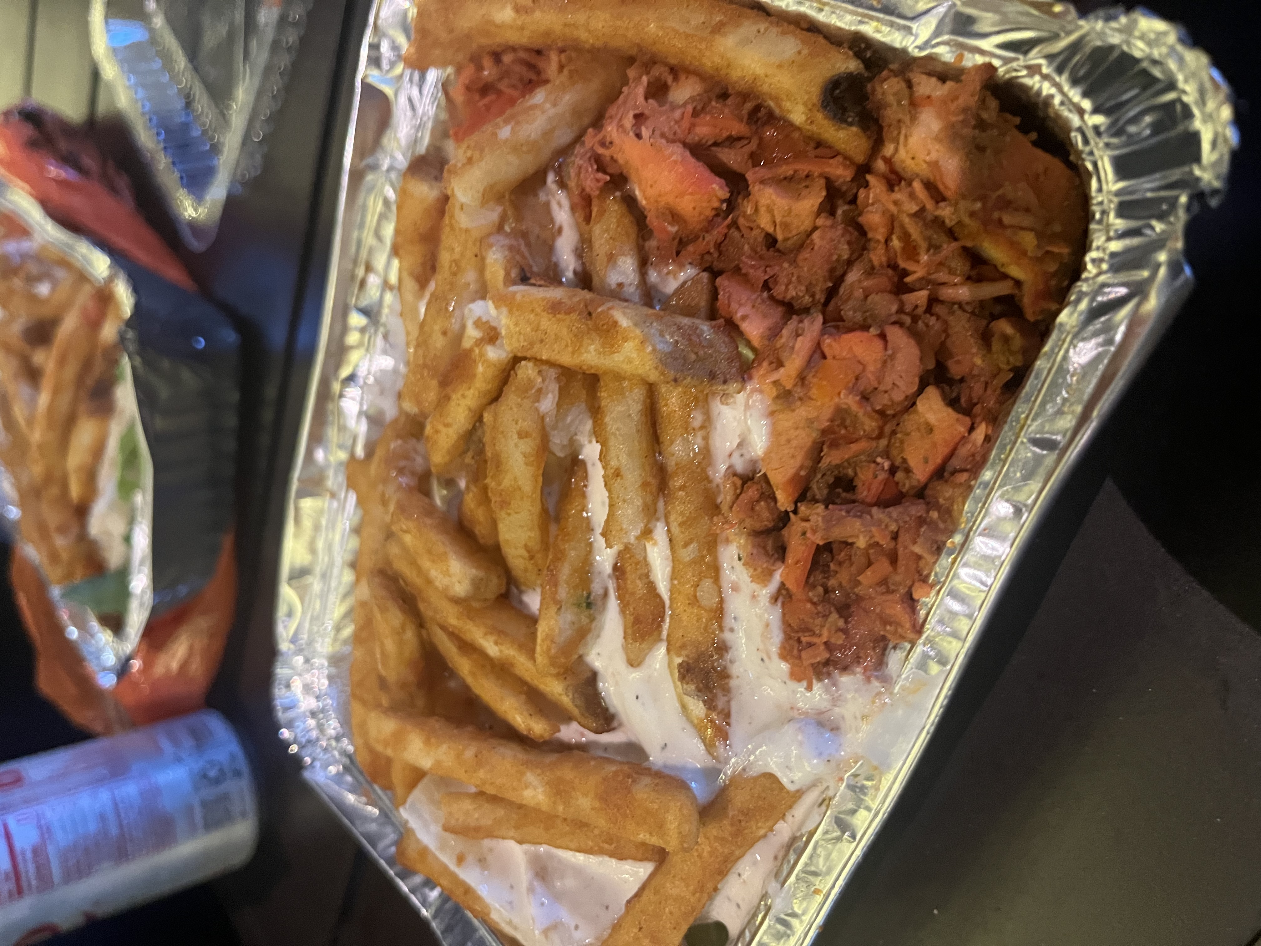 An aluminum tray with chicken and fries