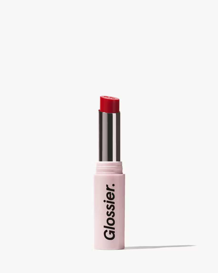 Glossier ultra lip lipstick in shade fete, which is a bright red. pink tube with white background