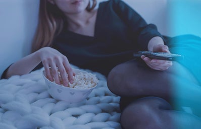 Girl eating popcorn watching TV