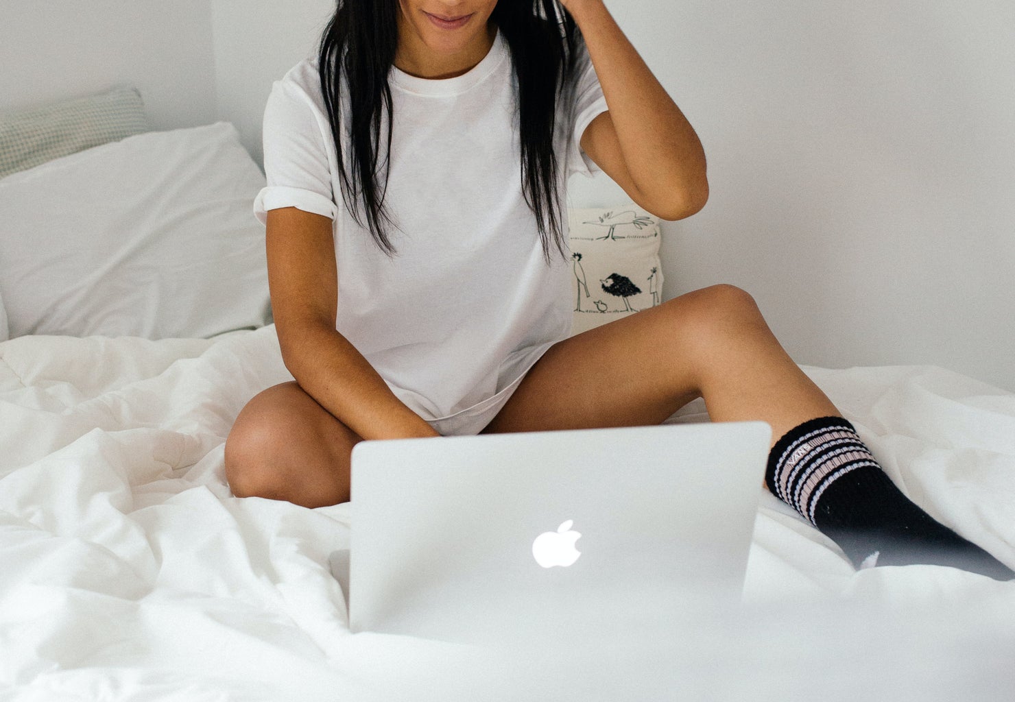 Woman sitting on bed with laptop