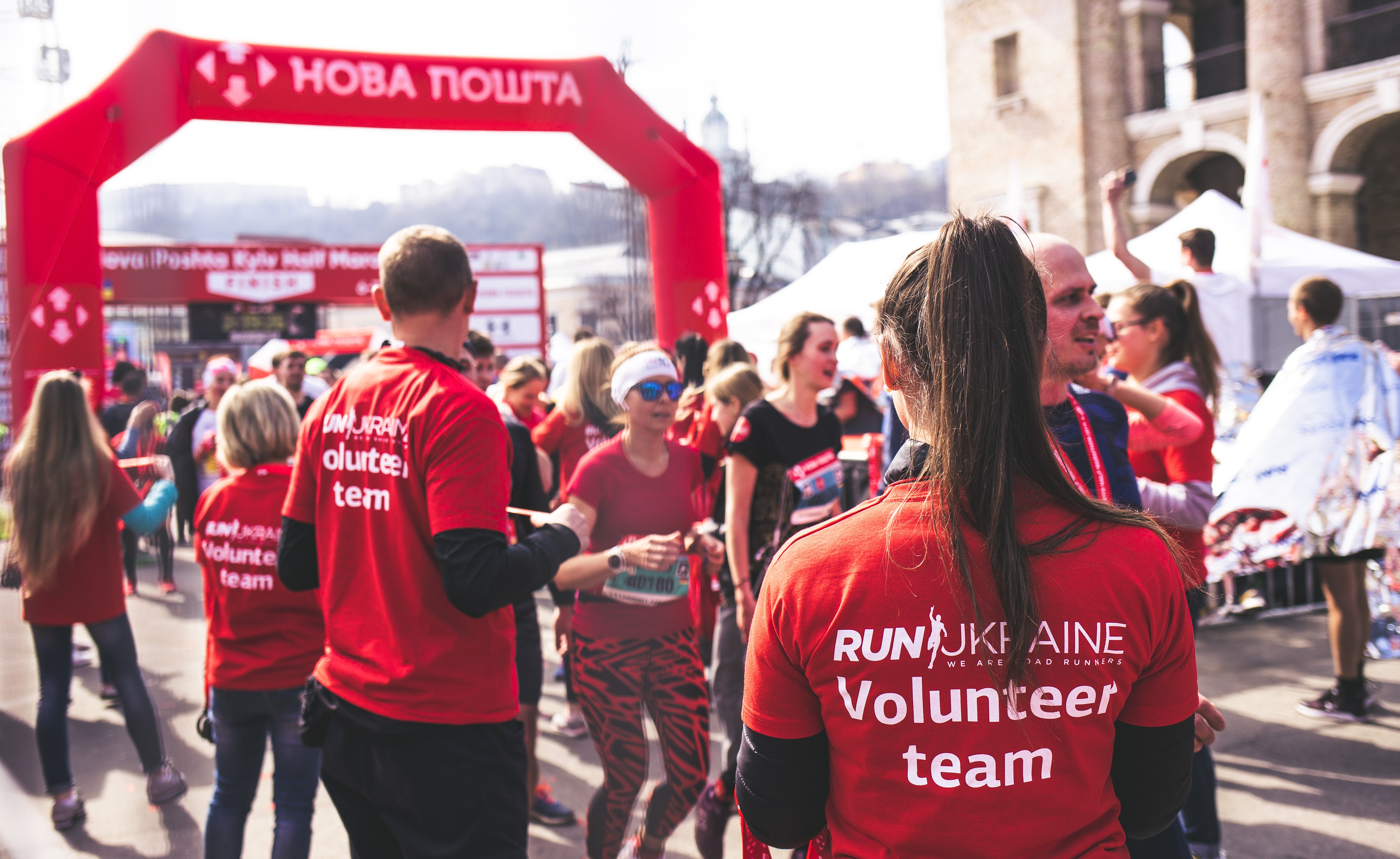 Group of volunteers in red shirts at an outdoor race