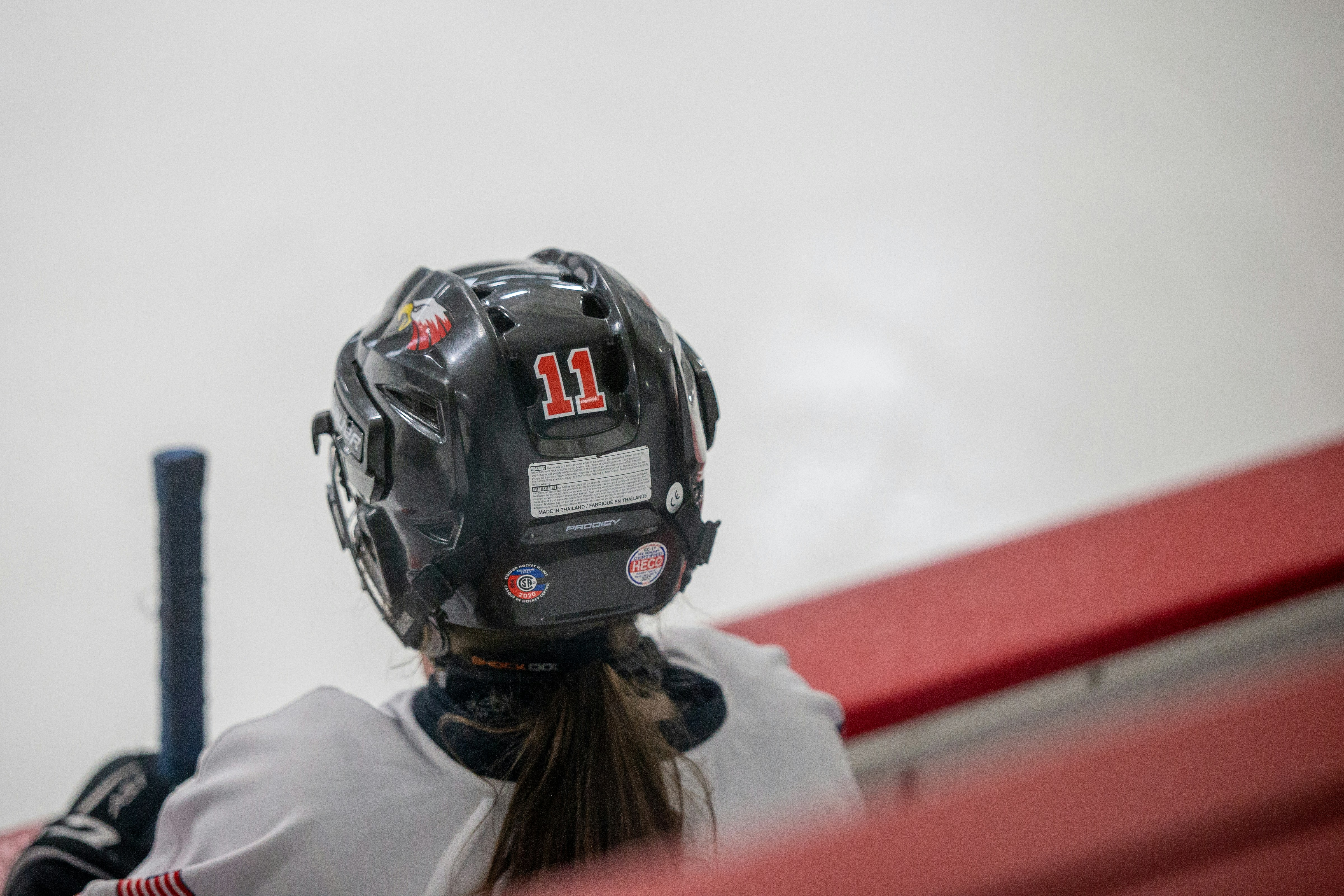 a female hockey player wearing a helmet and holding a stick