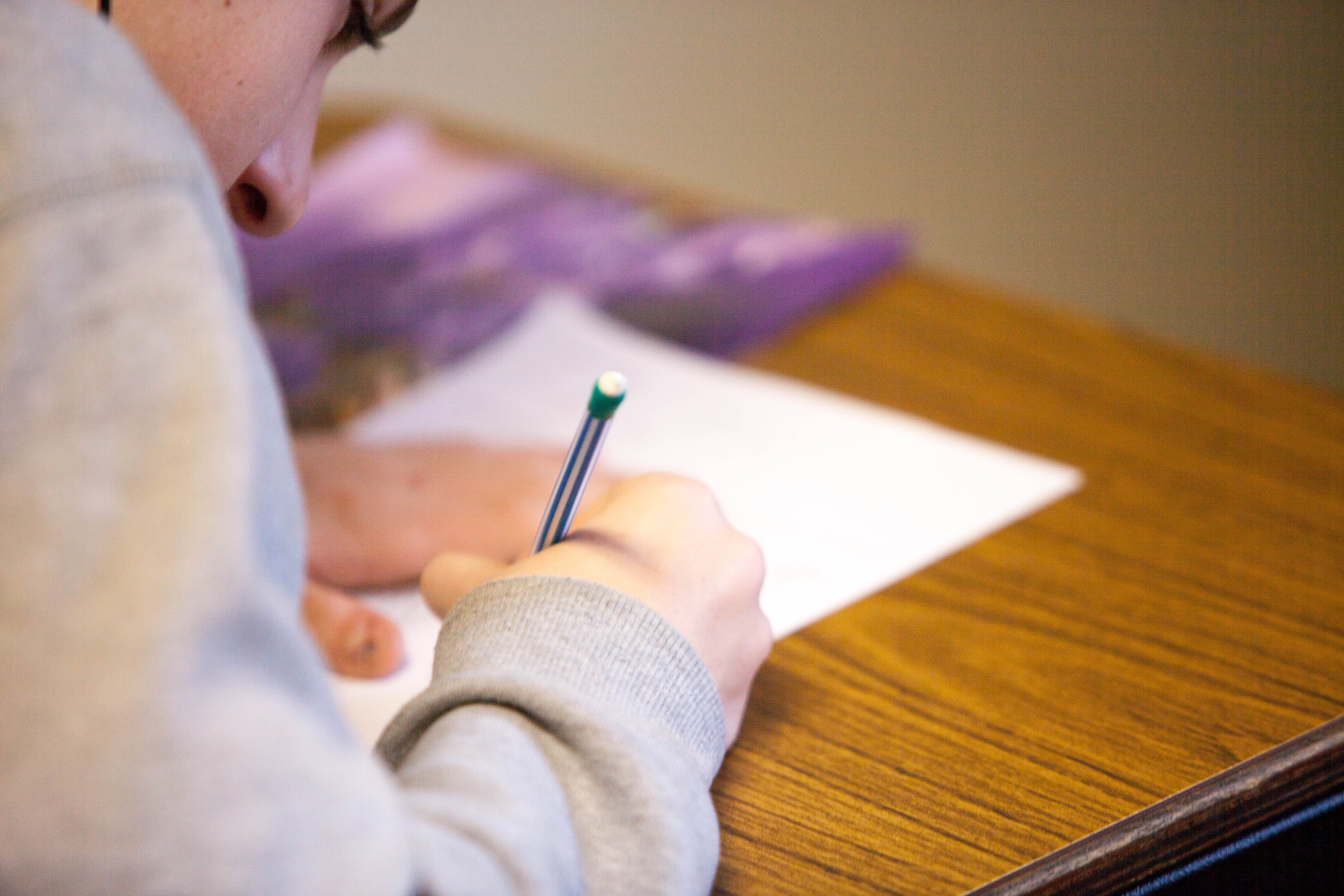 girl sits at desk taking test