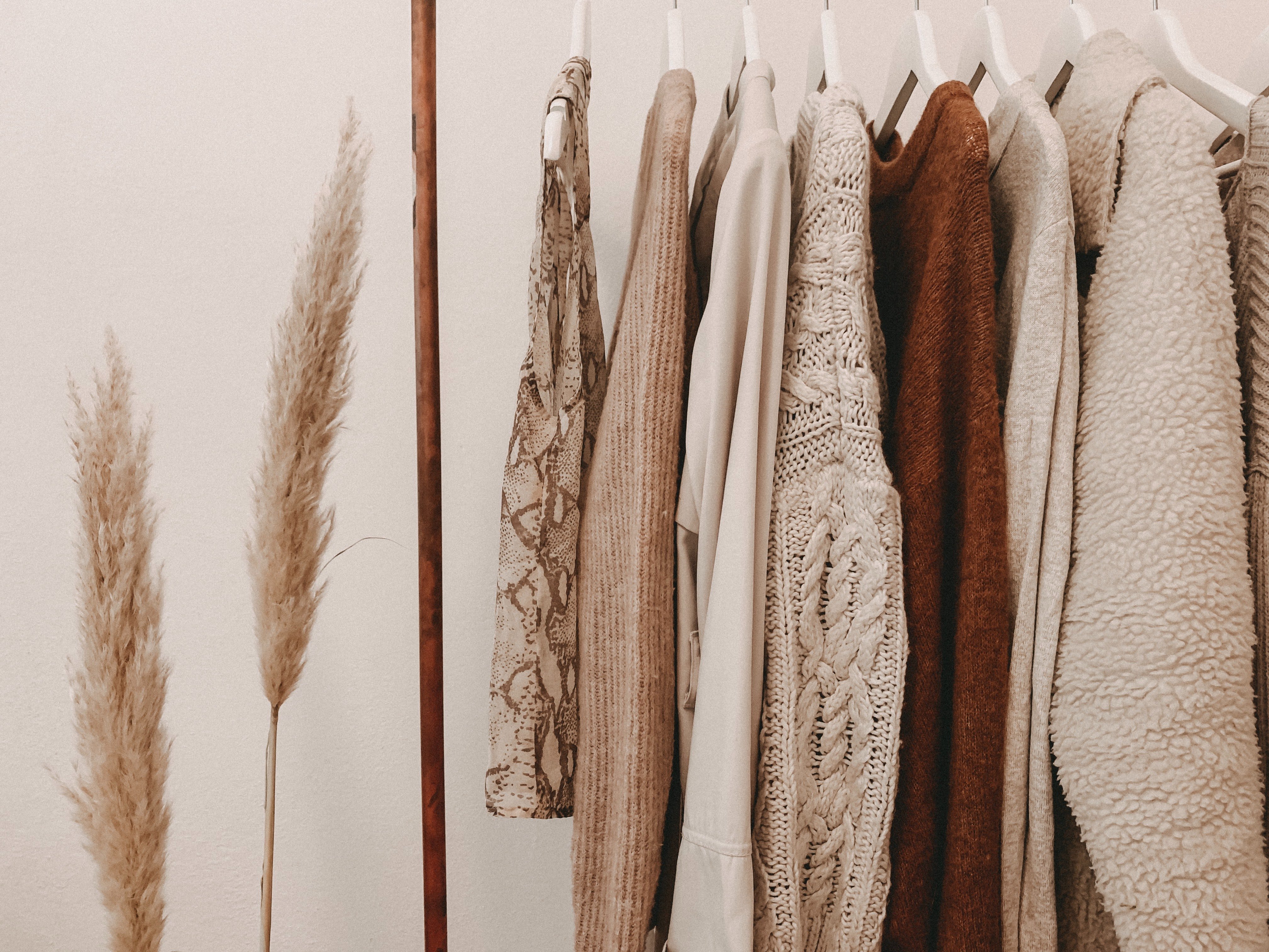 sweaters on clothing rack, sheaf of wheat next to it
