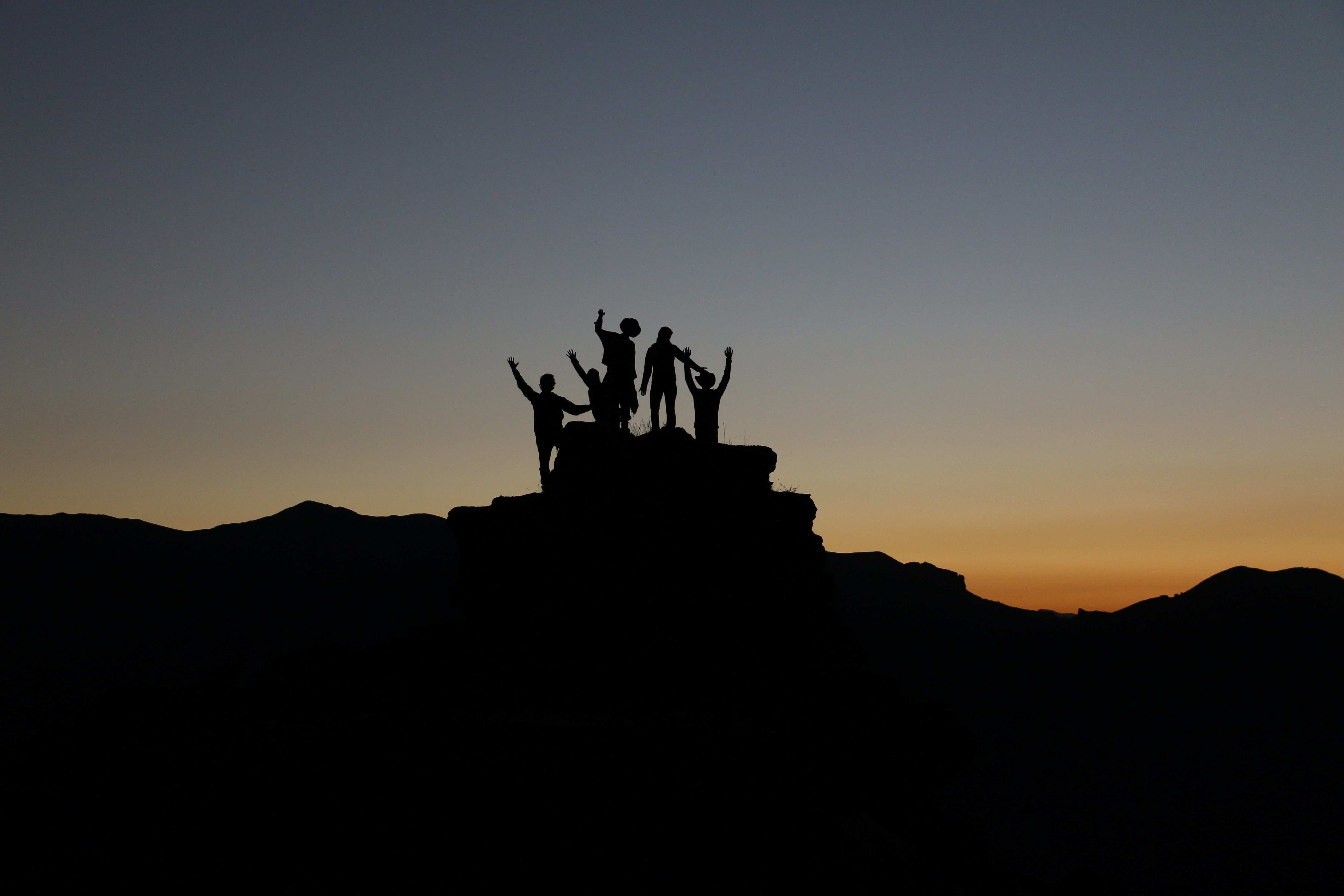 silhouette of people standing on highland during golden hour