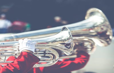 band in red playing silver instrument