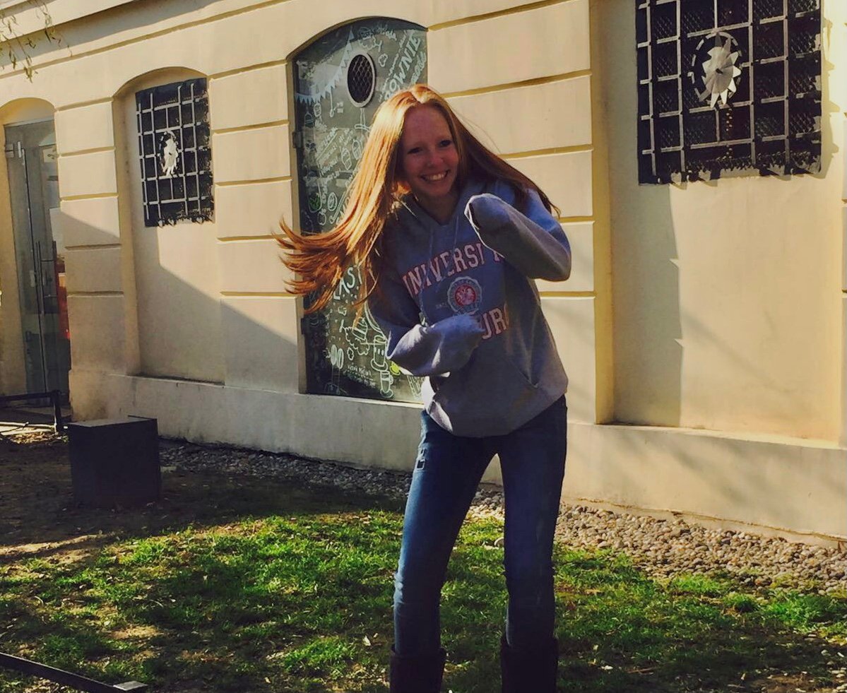 Redhead in a fighting position with her hands tucked into her hoodie sleeves
