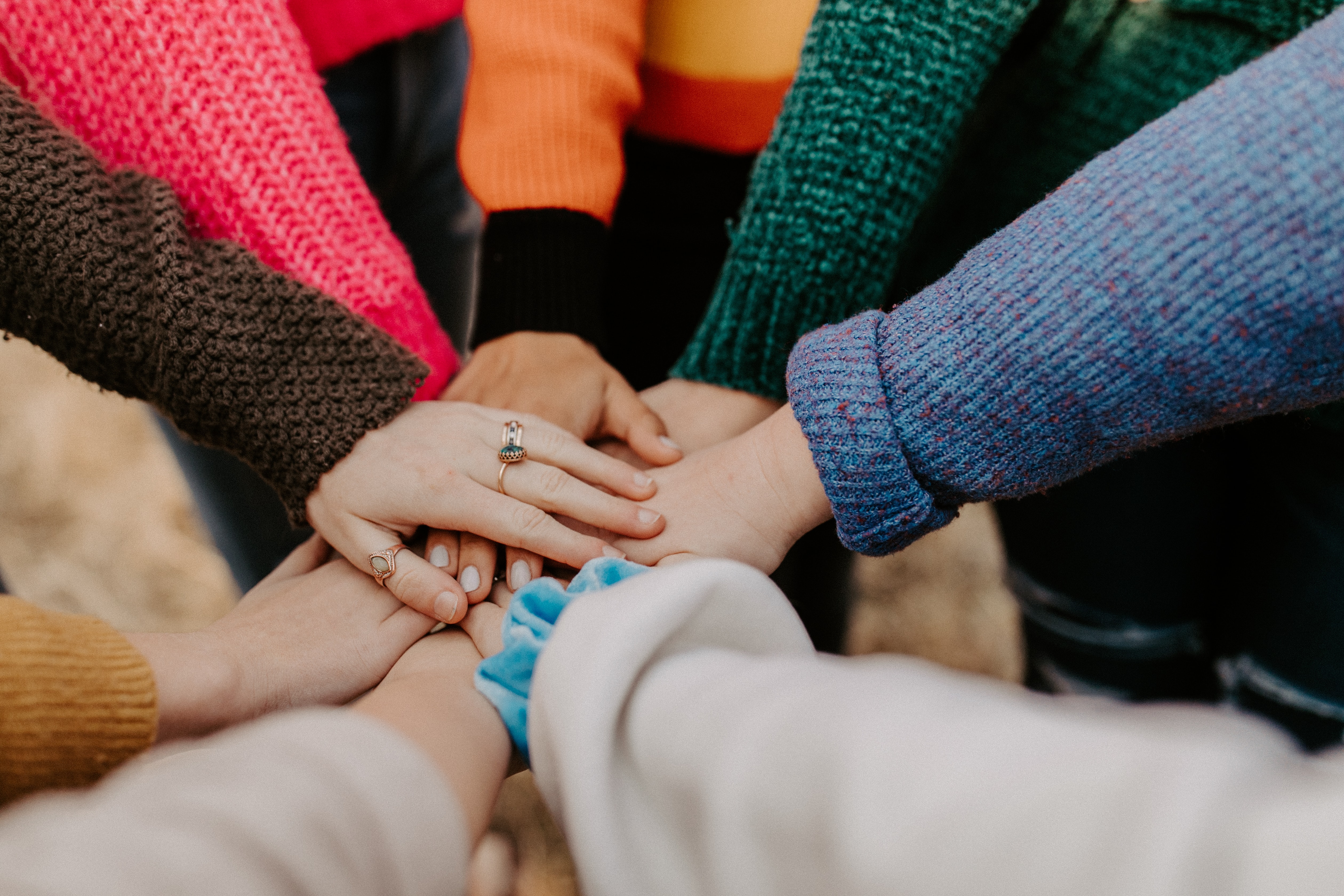 8 women in circle stacking hands