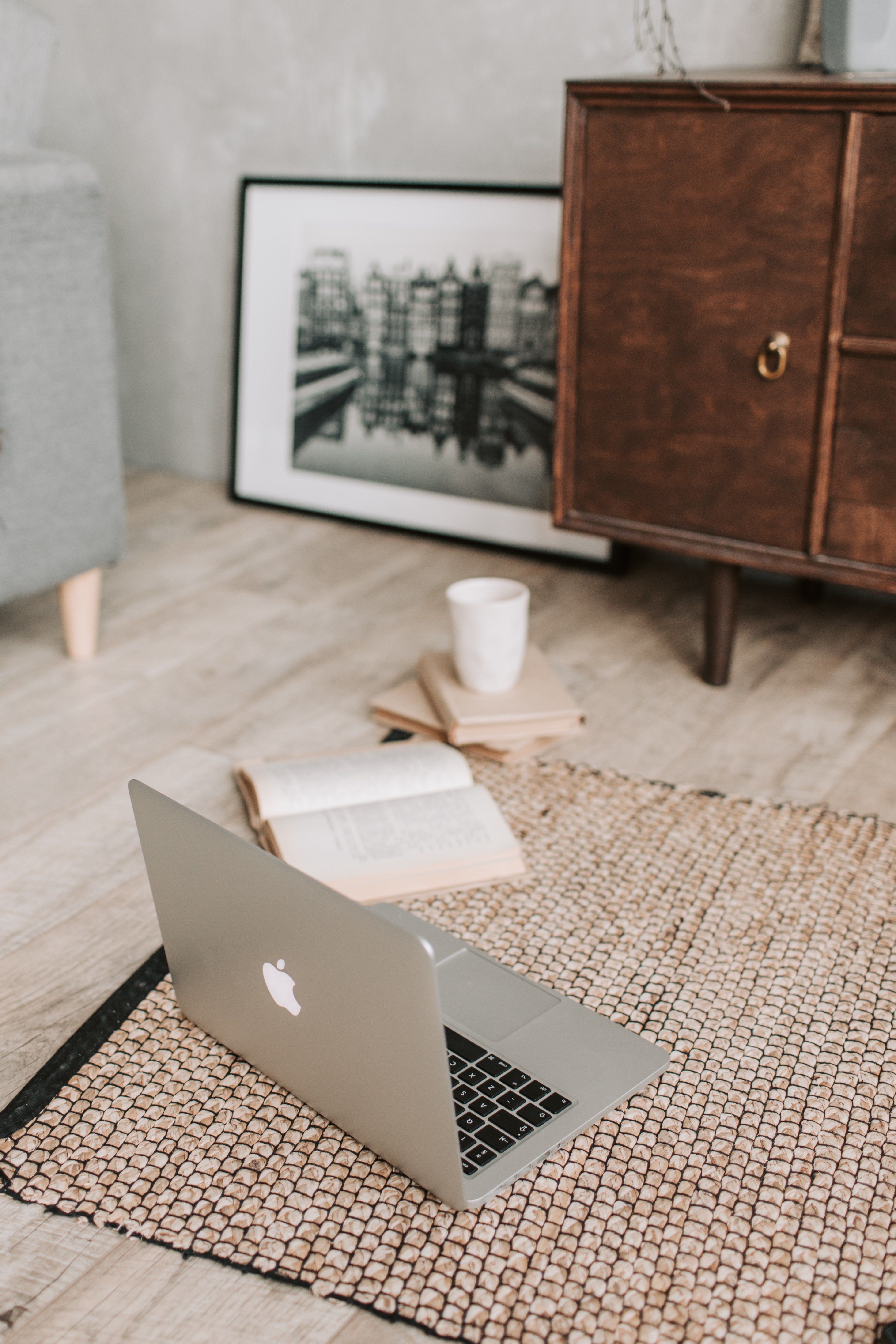 Laptop and books on floor carpet by Vlada Karpovich