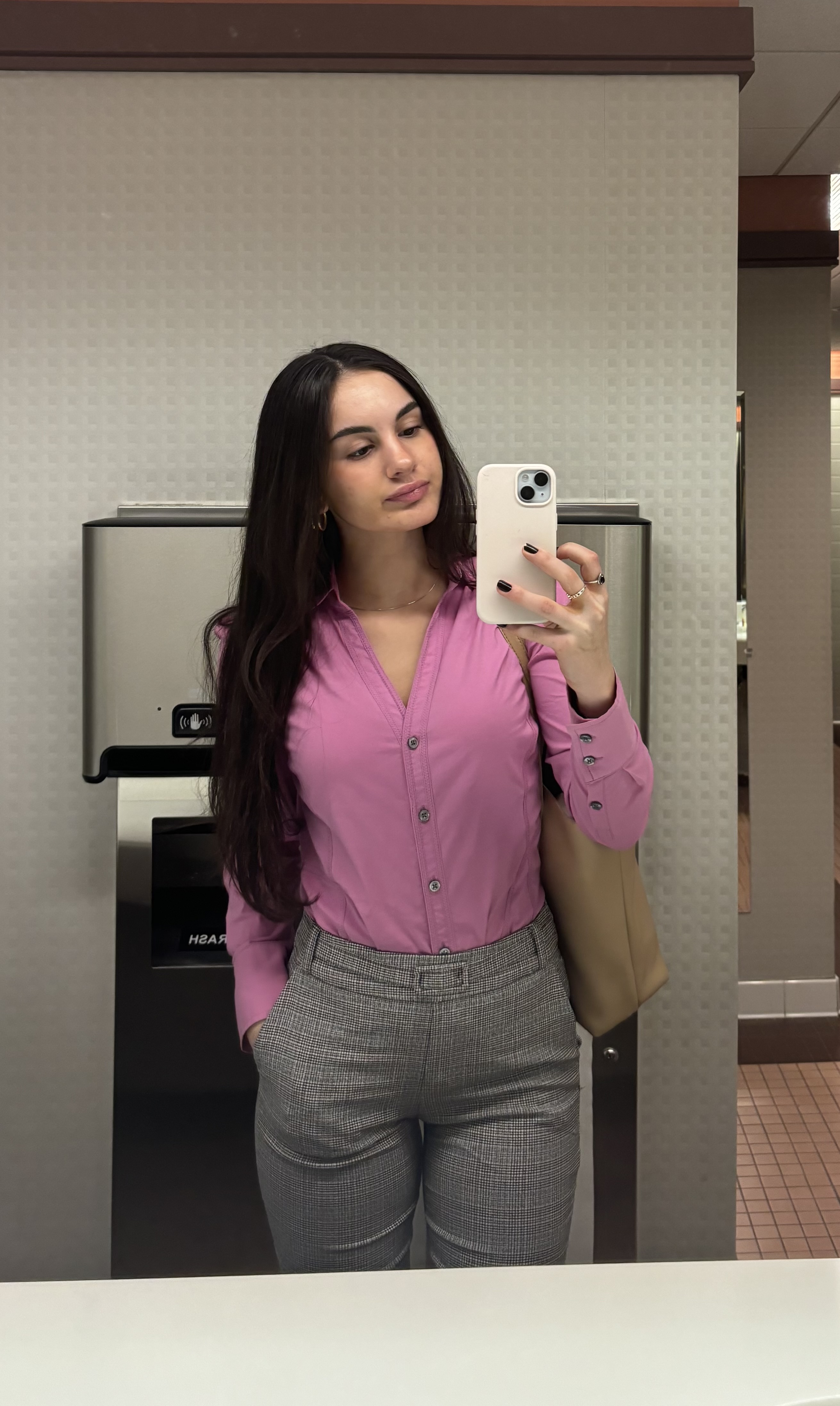 Girl posing in front of mirror taking picture of self.