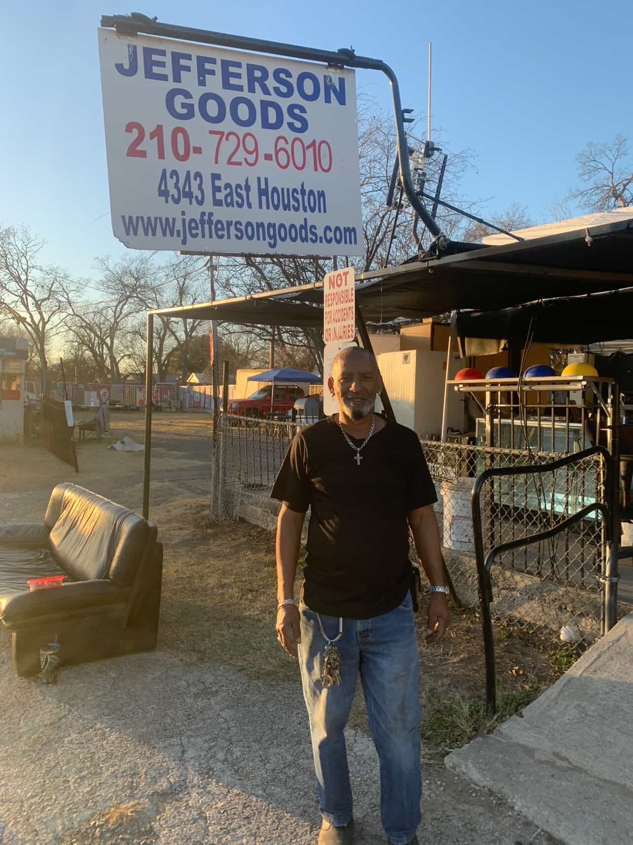 African America male standing in front of store sign.