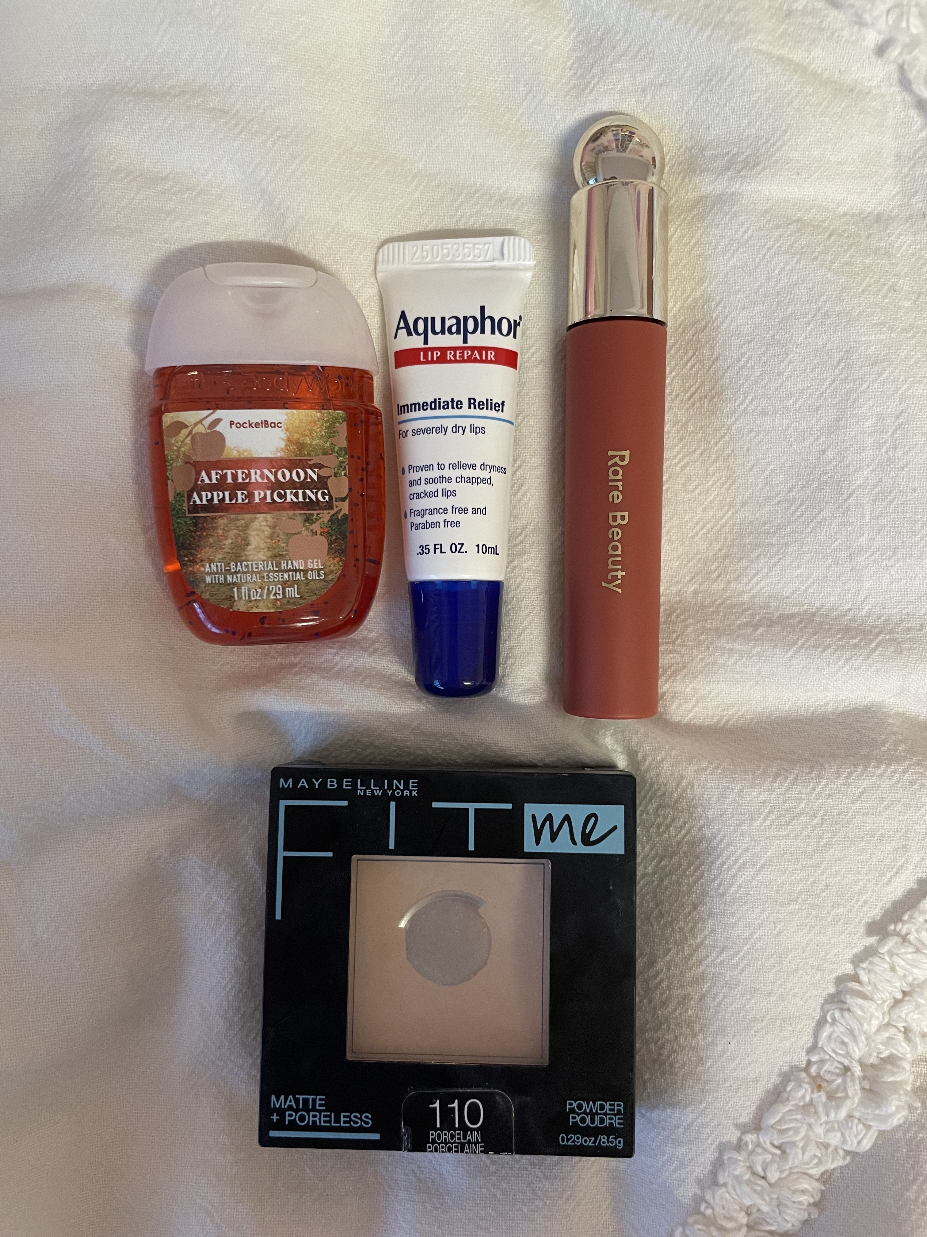 hand sanitizer, lip gloss, face powder, and aquaphor lip balm