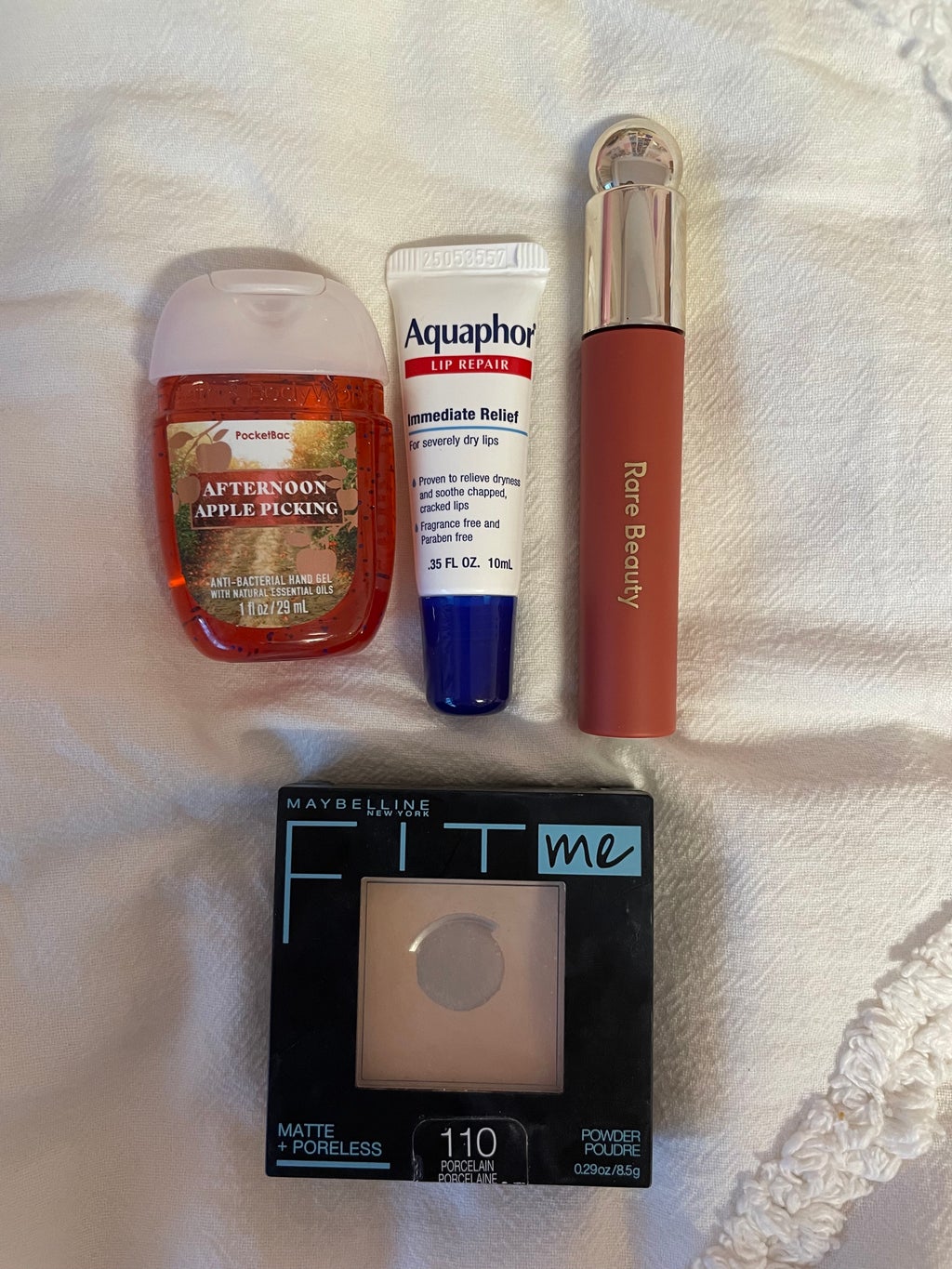 hand sanitizer, lip gloss, face powder, and aquaphor lip balm