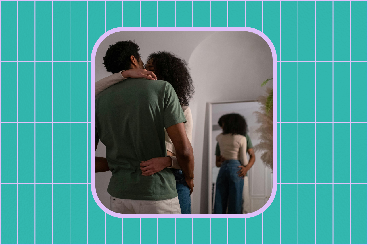 Couple kissing in front of a mirror.