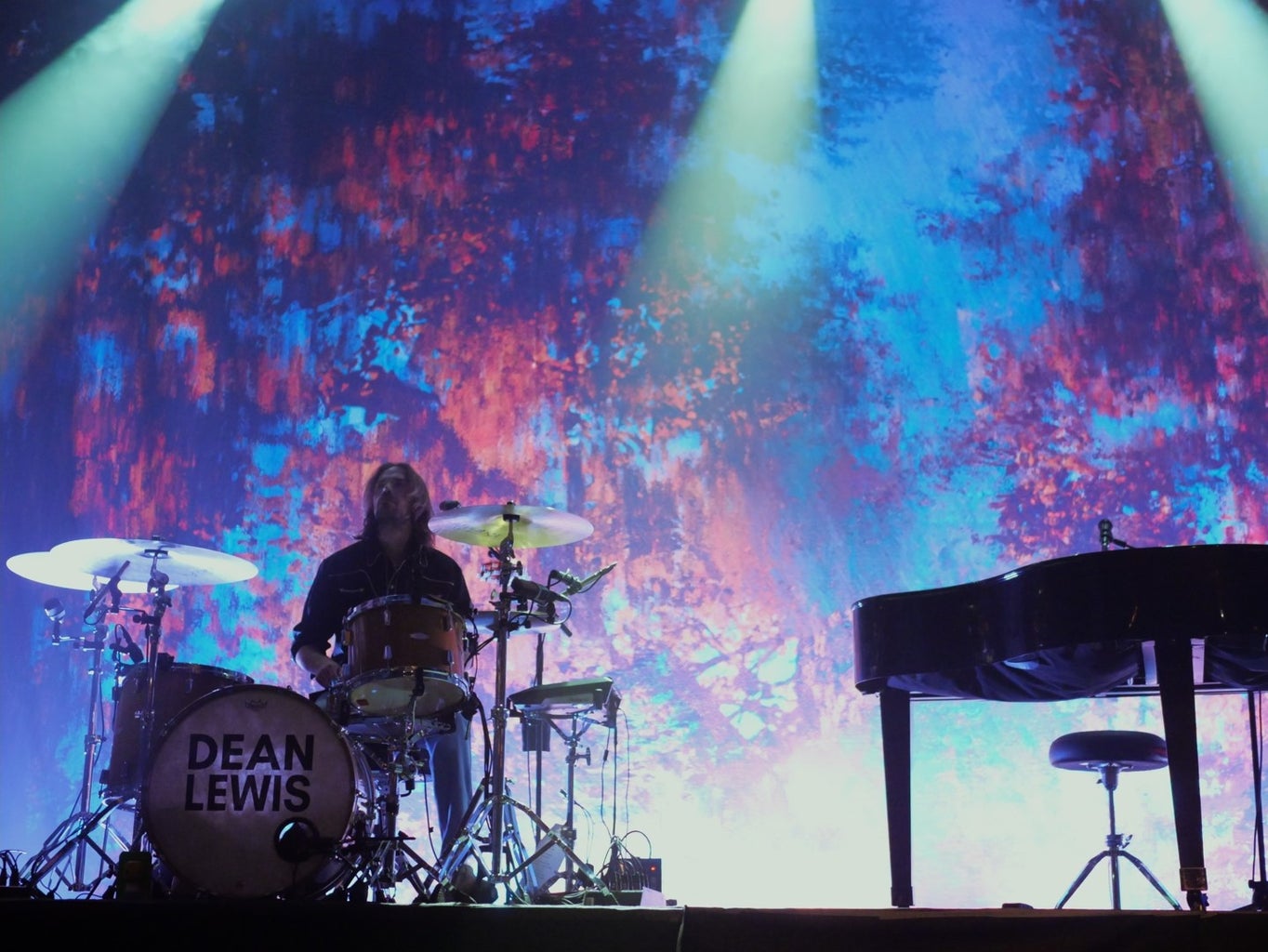 silhouette of drummer in front of a backdrop with blue and pink hues silhouette of drummer in front of a backdrop with blue and pink hues