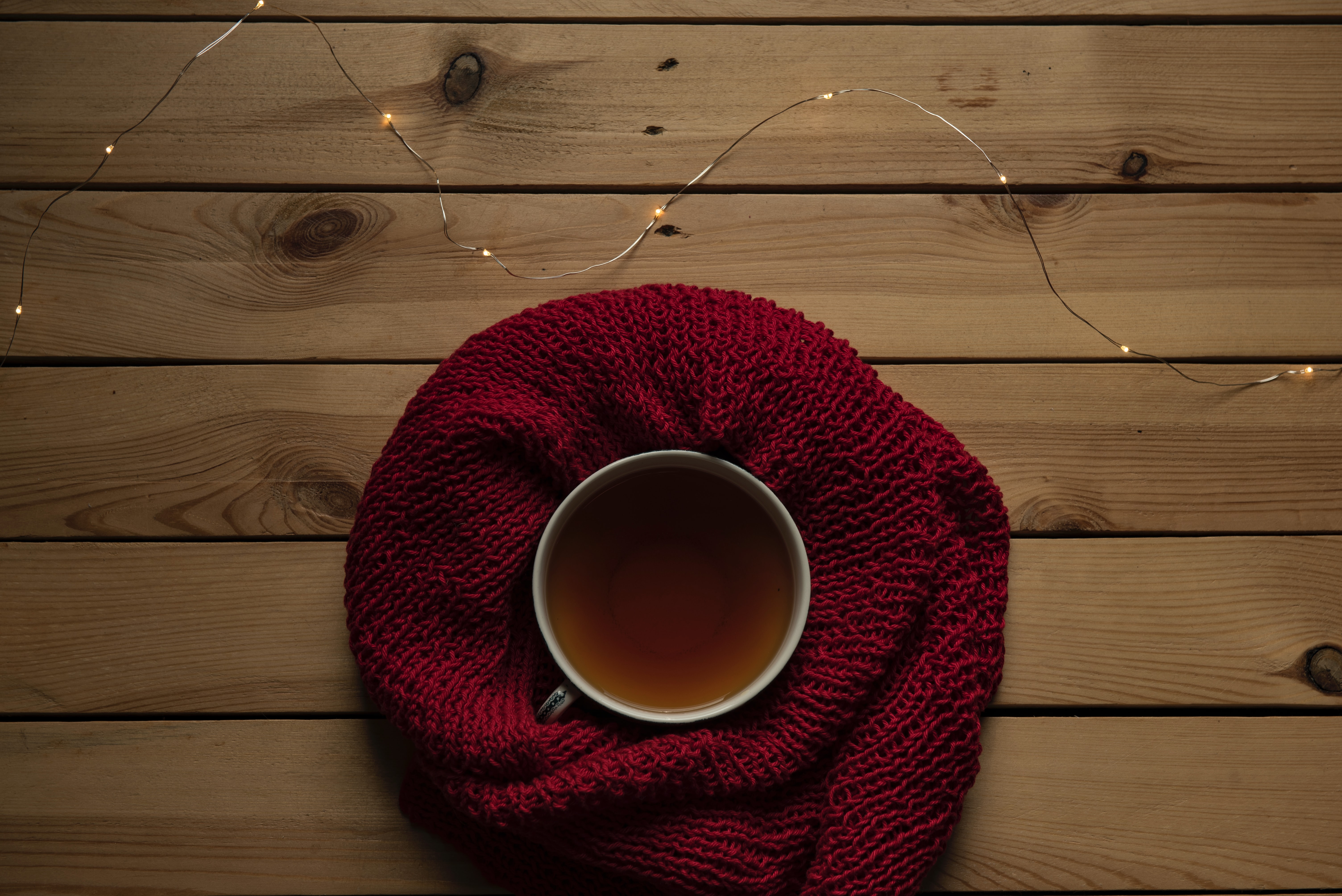 red scarf around coffee mug and lights on the table
