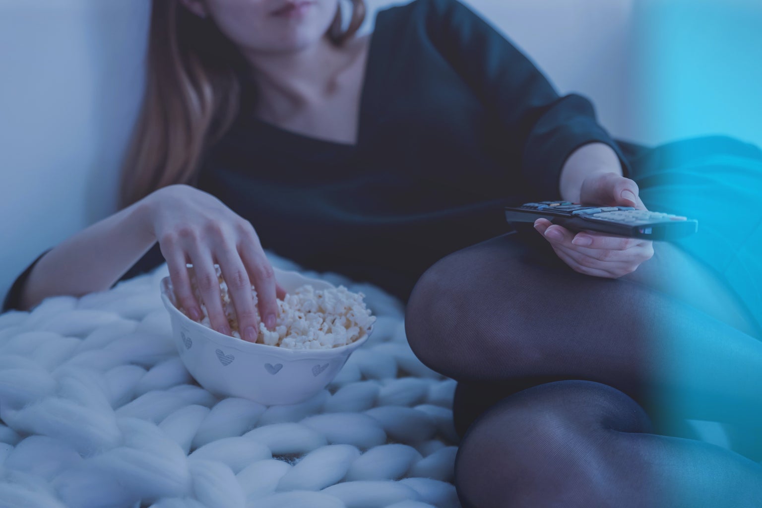 woman watching tv eating popcorn