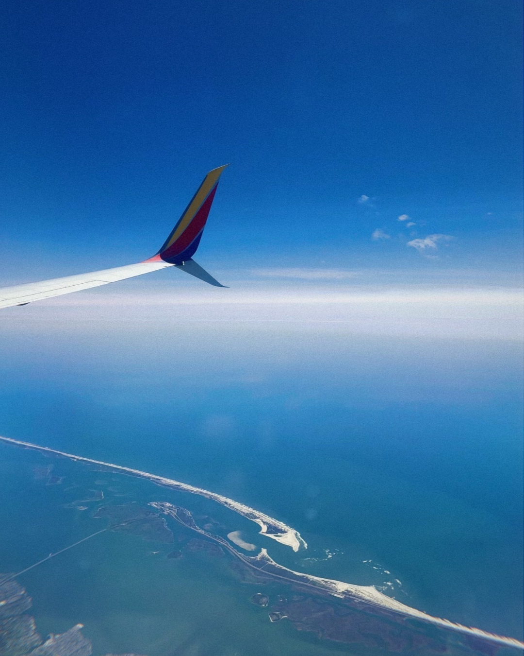 plane wing over the ocean