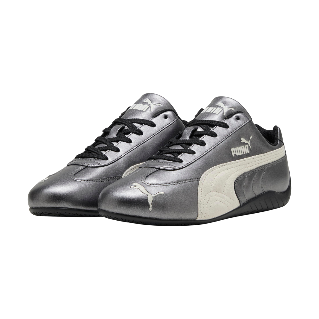 Silver PUMA sneakers with black laces, an off-white side stripe, and the PUMA logo on the side and front. Sleek and sporty design.