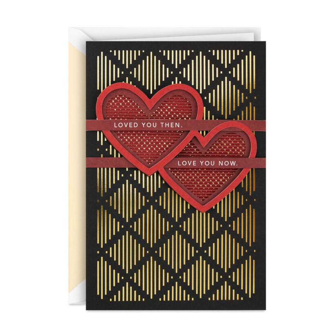 A card with a black and gold geometric pattern features two red hearts. Text reads \