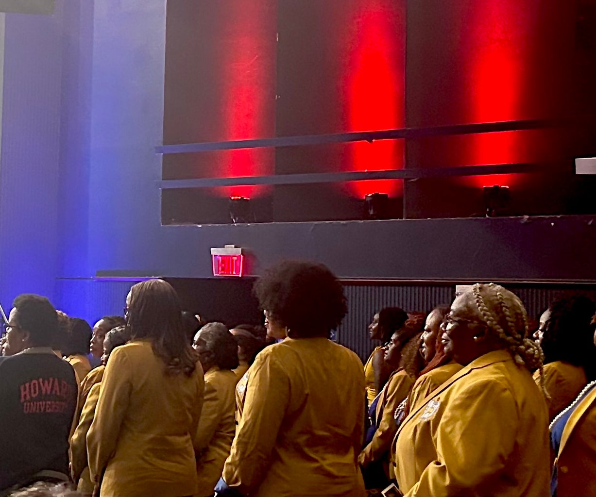 Sigma Gamma Rho members stand to be recognized and celebrated by audience attendees.