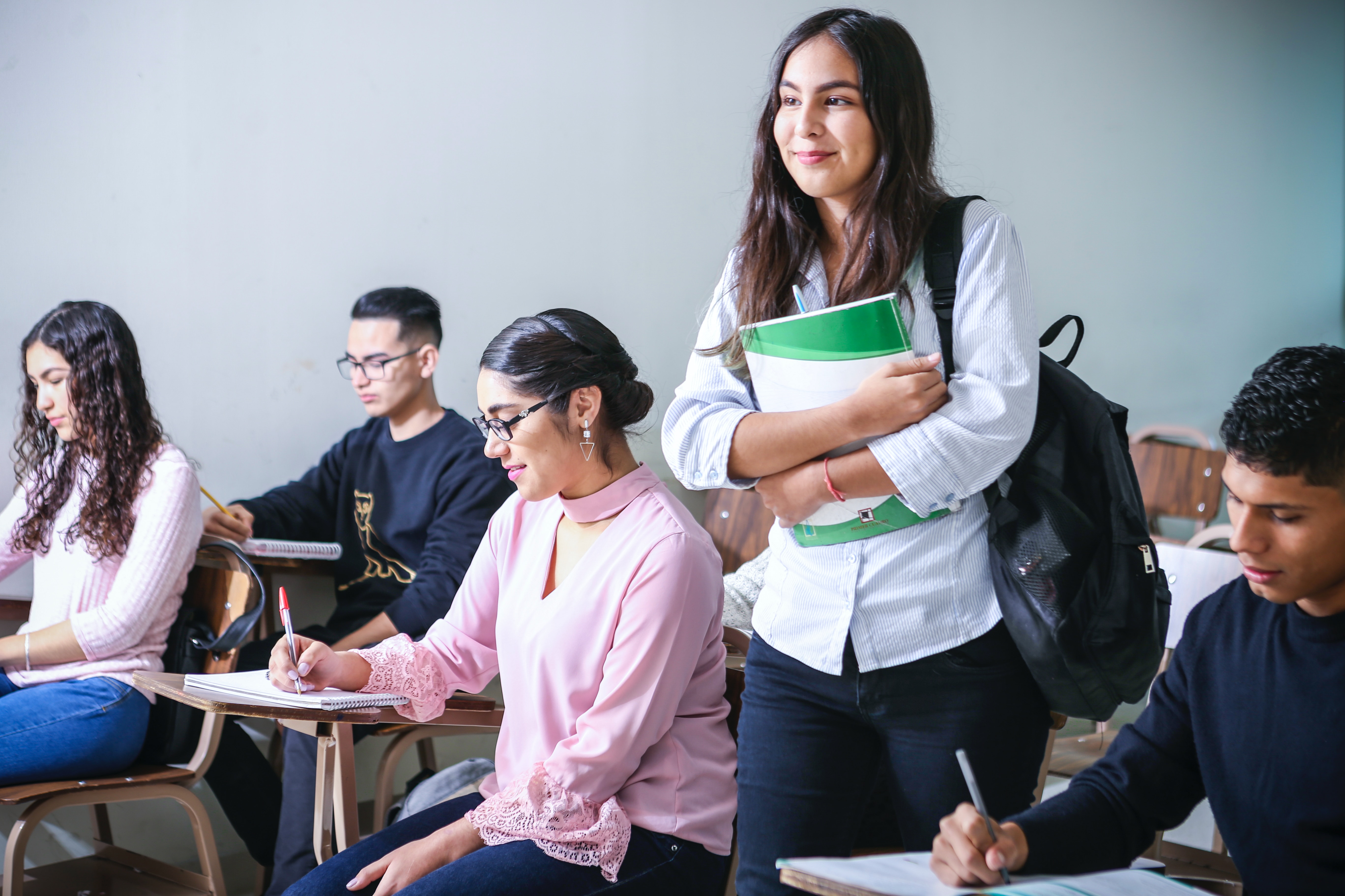 Girl smiling while holding book in class