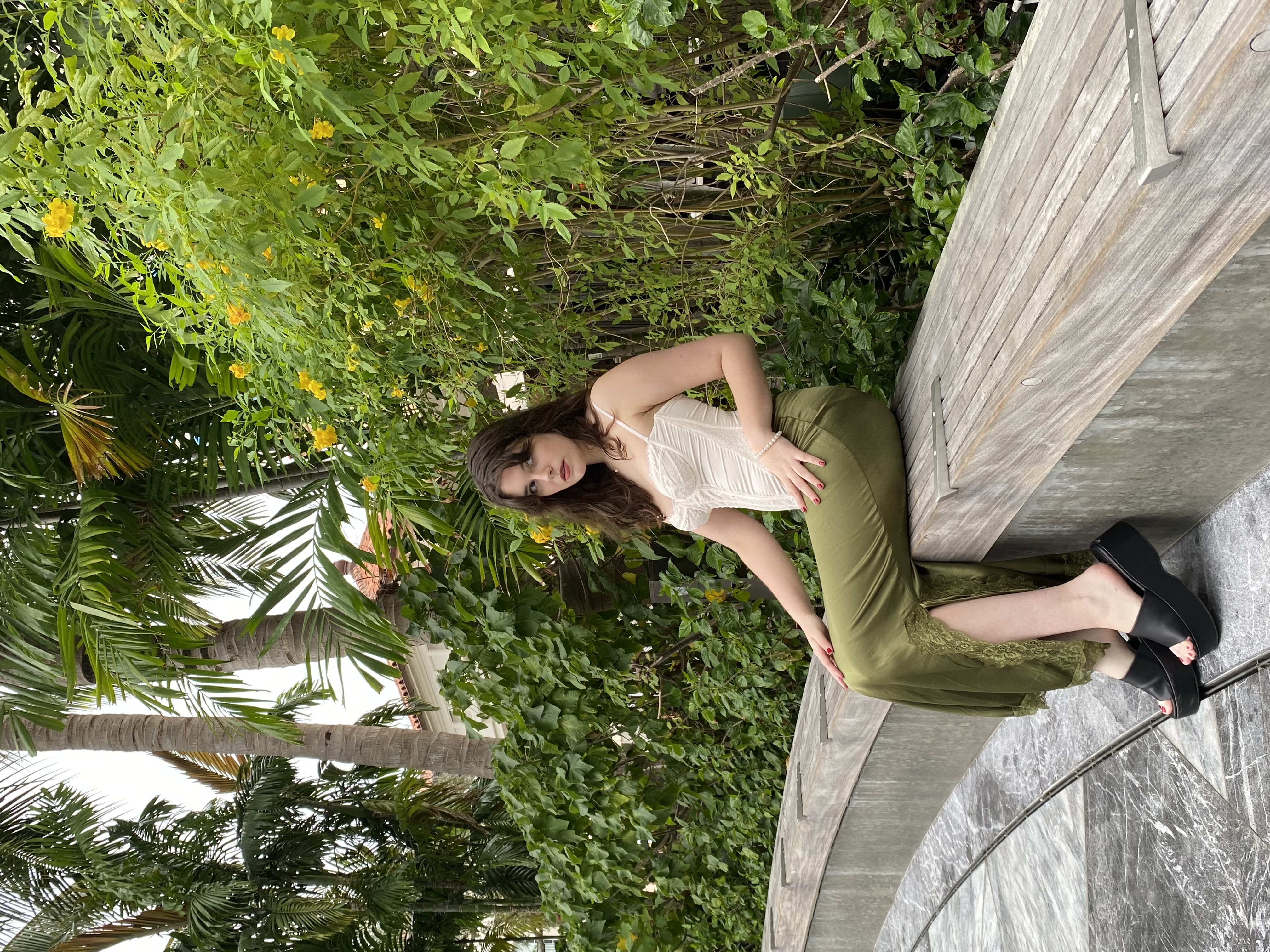Girl in green skirt against plants