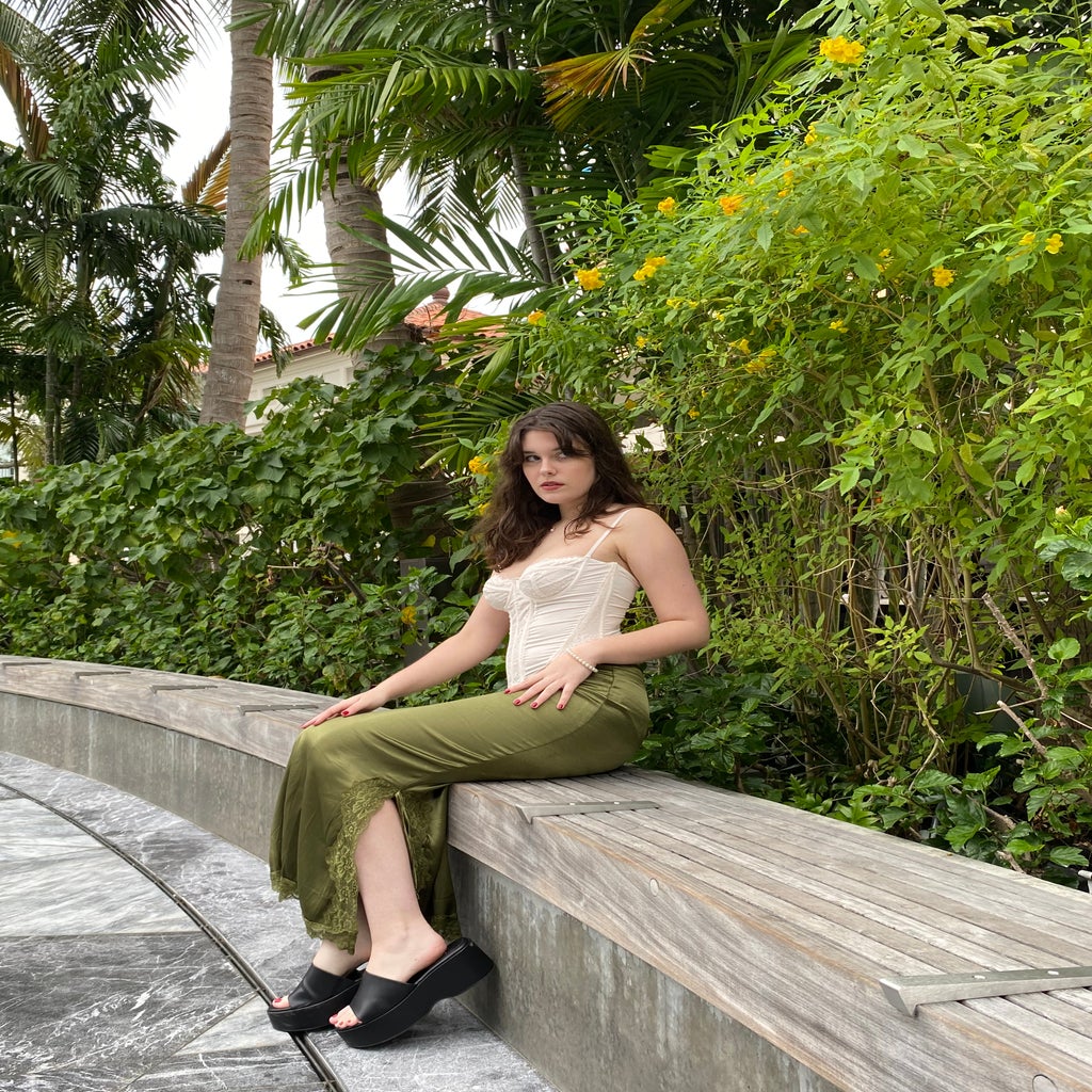 Girl in green skirt against plants