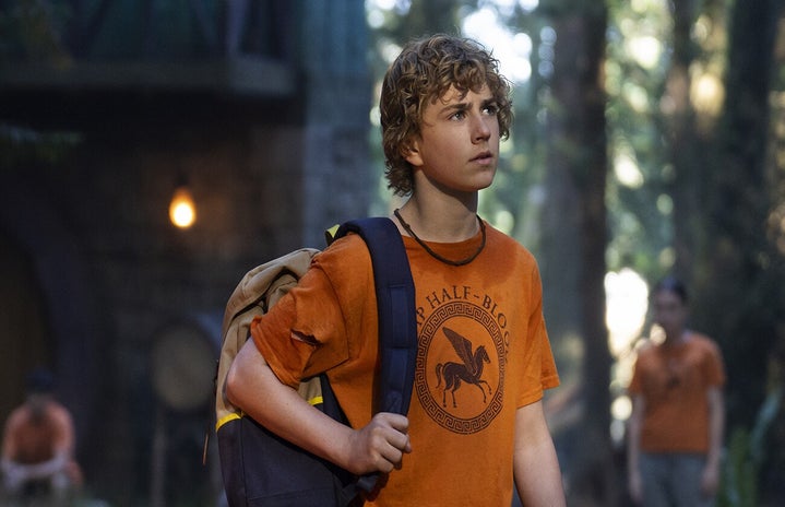 percy jackson and the olympians official poster by disney plus. Boy with a backpack standing in the middle of the woods