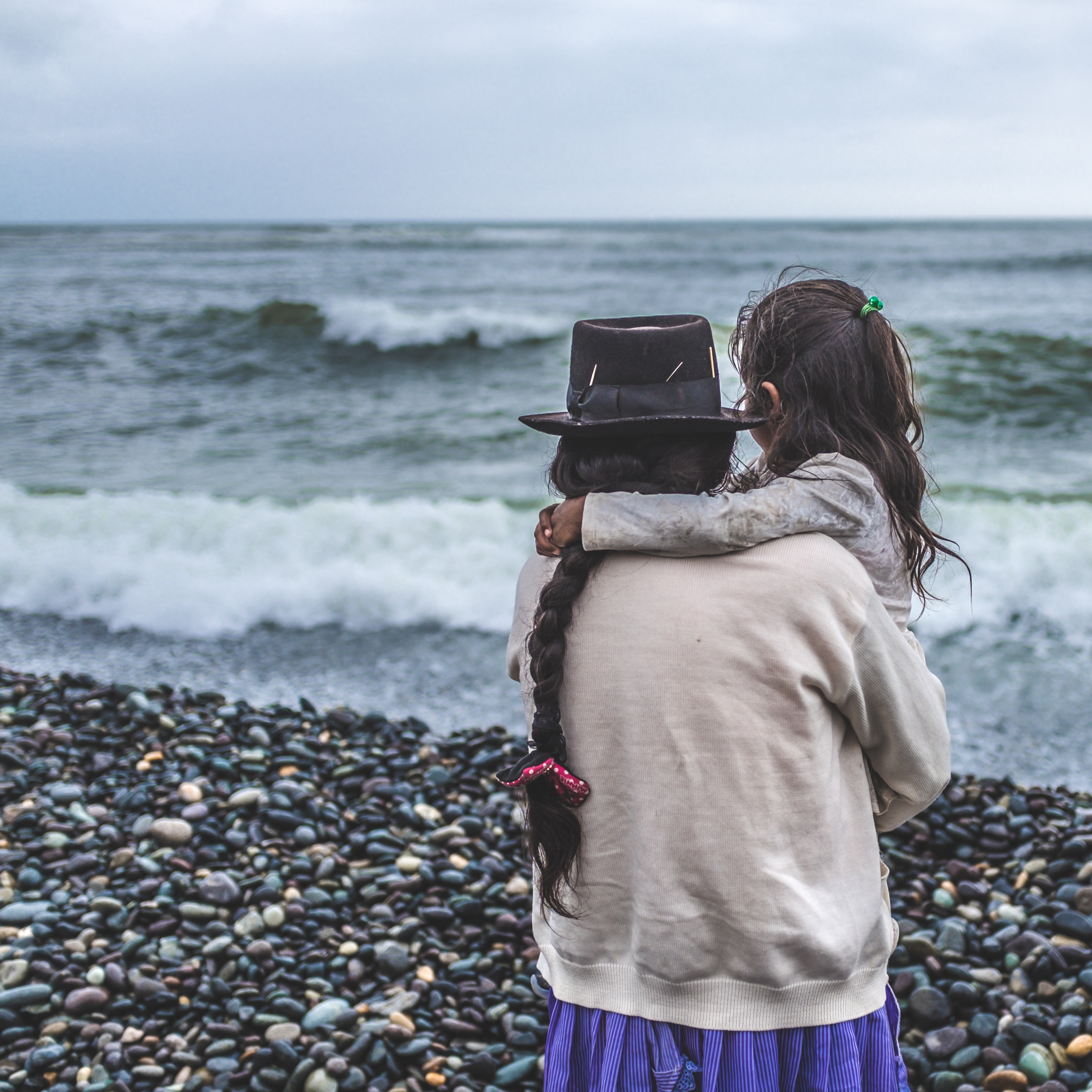 mother holding daughter on the beach