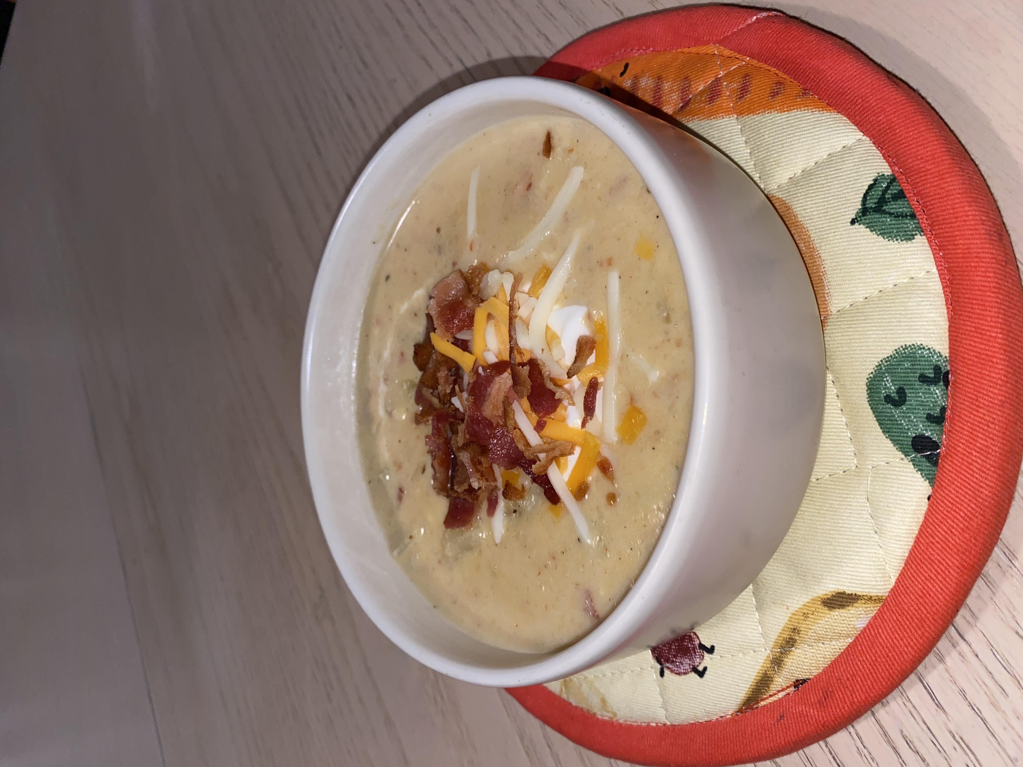 bowl of soup with cheese and bacon on top