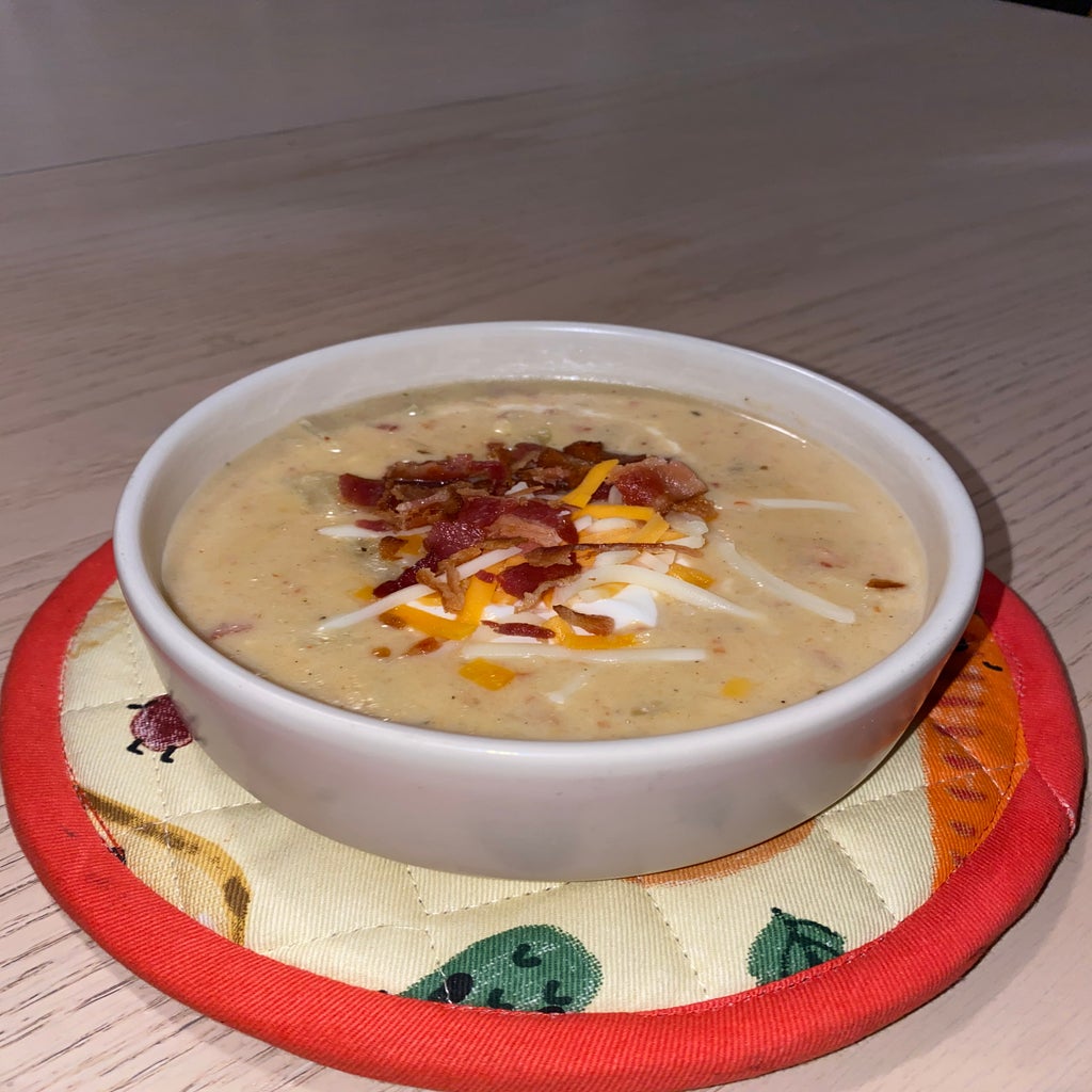 bowl of soup with cheese and bacon on top