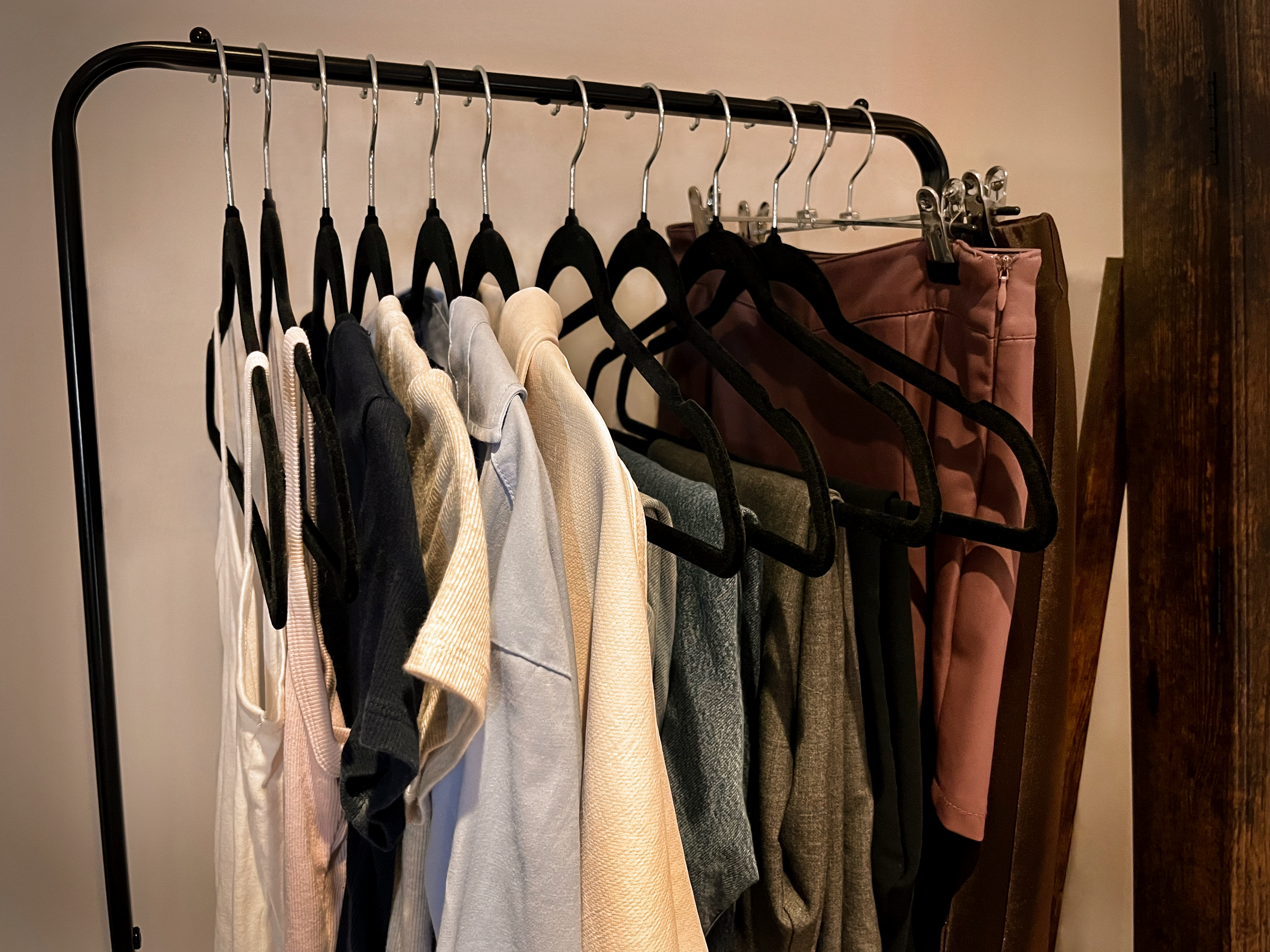 A rack of clothing against a white wall.