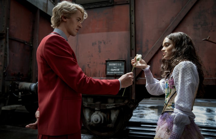 Coriolanus Snow handing a white rose to Lucy Gray Baird in \"The Hunger Games: The Ballad of Songbirds and Snakes\".