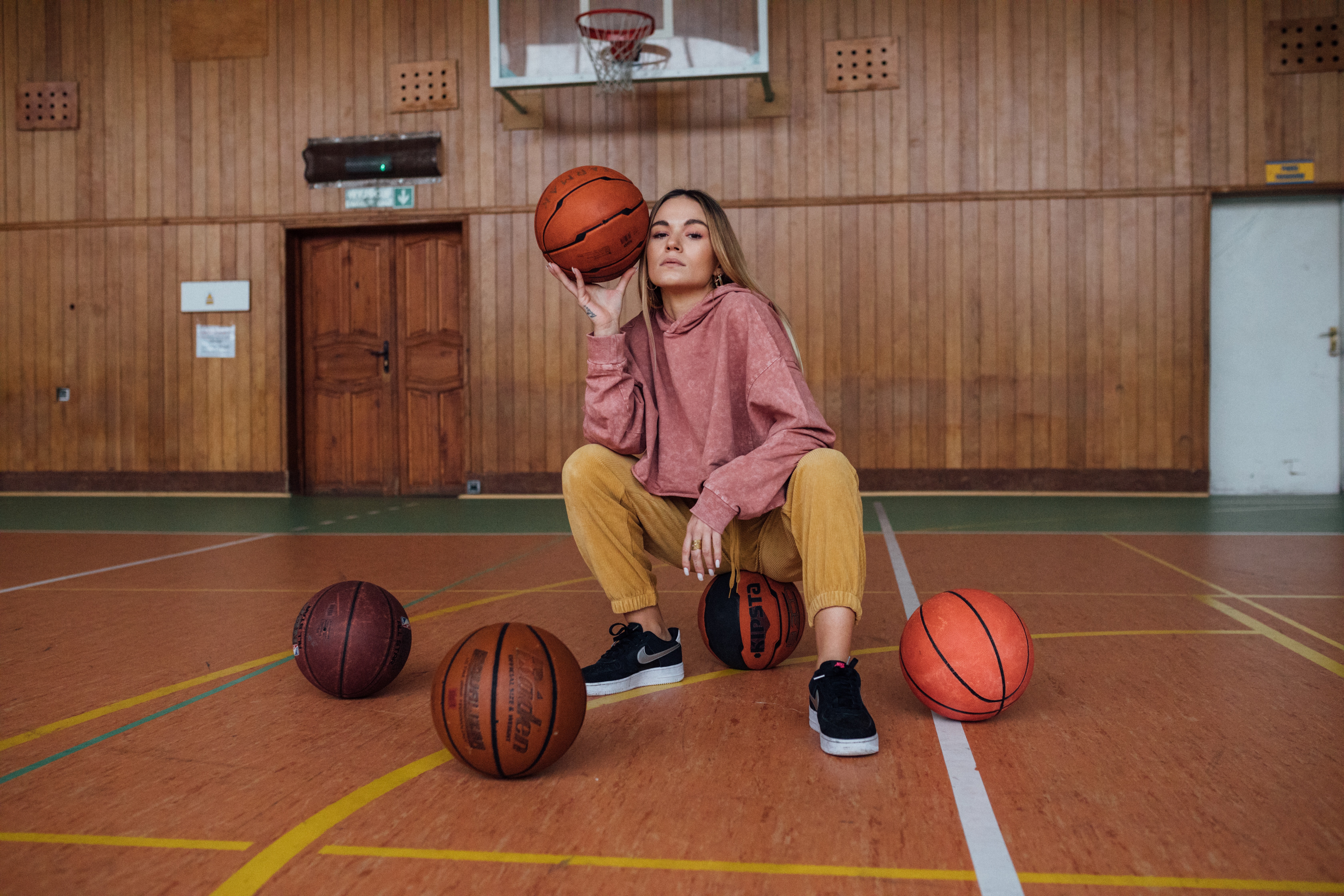 woman sitting and holding a basketball