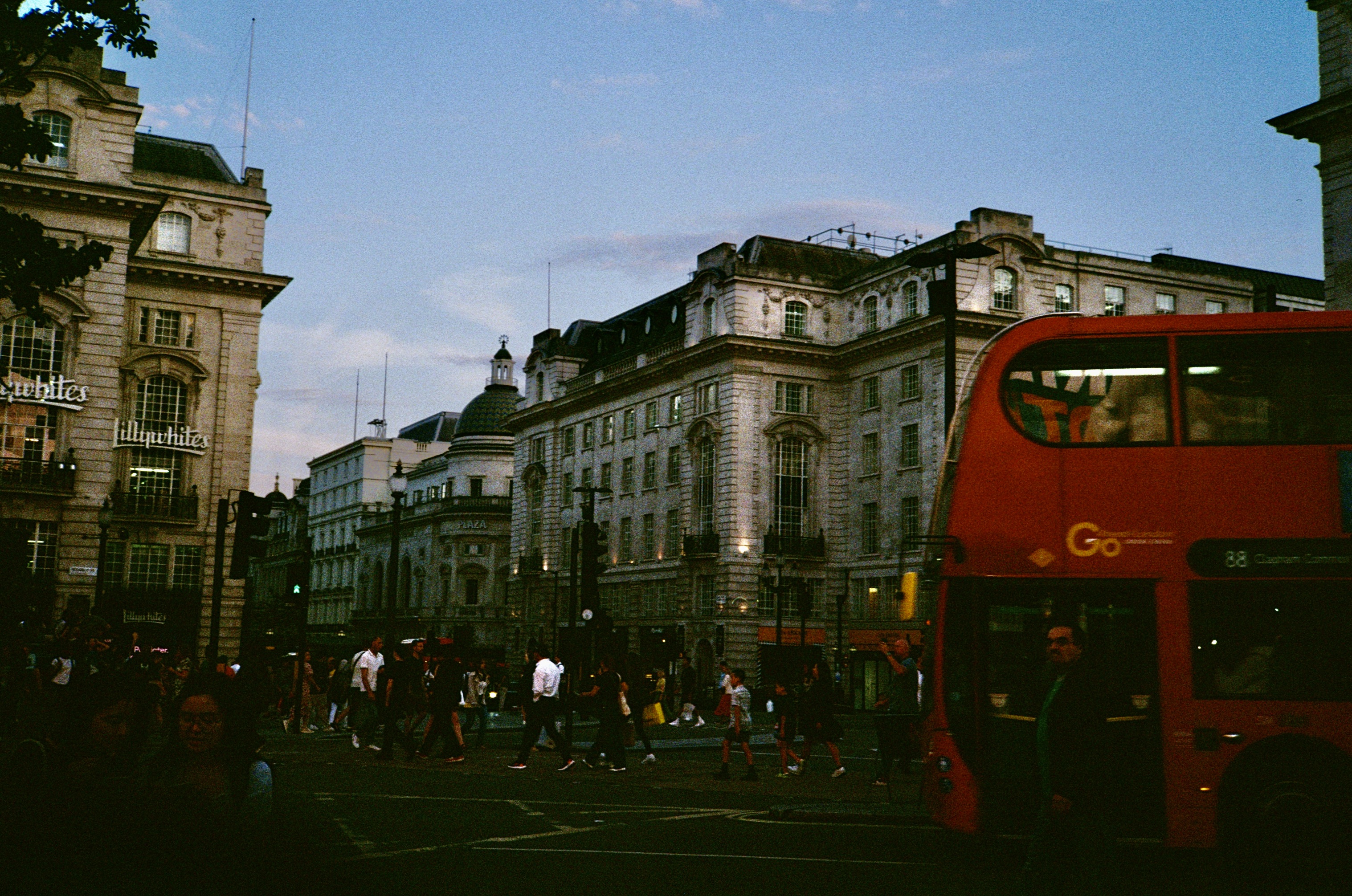 Photo of London city streets with crowds of people and a double decker bus in the background