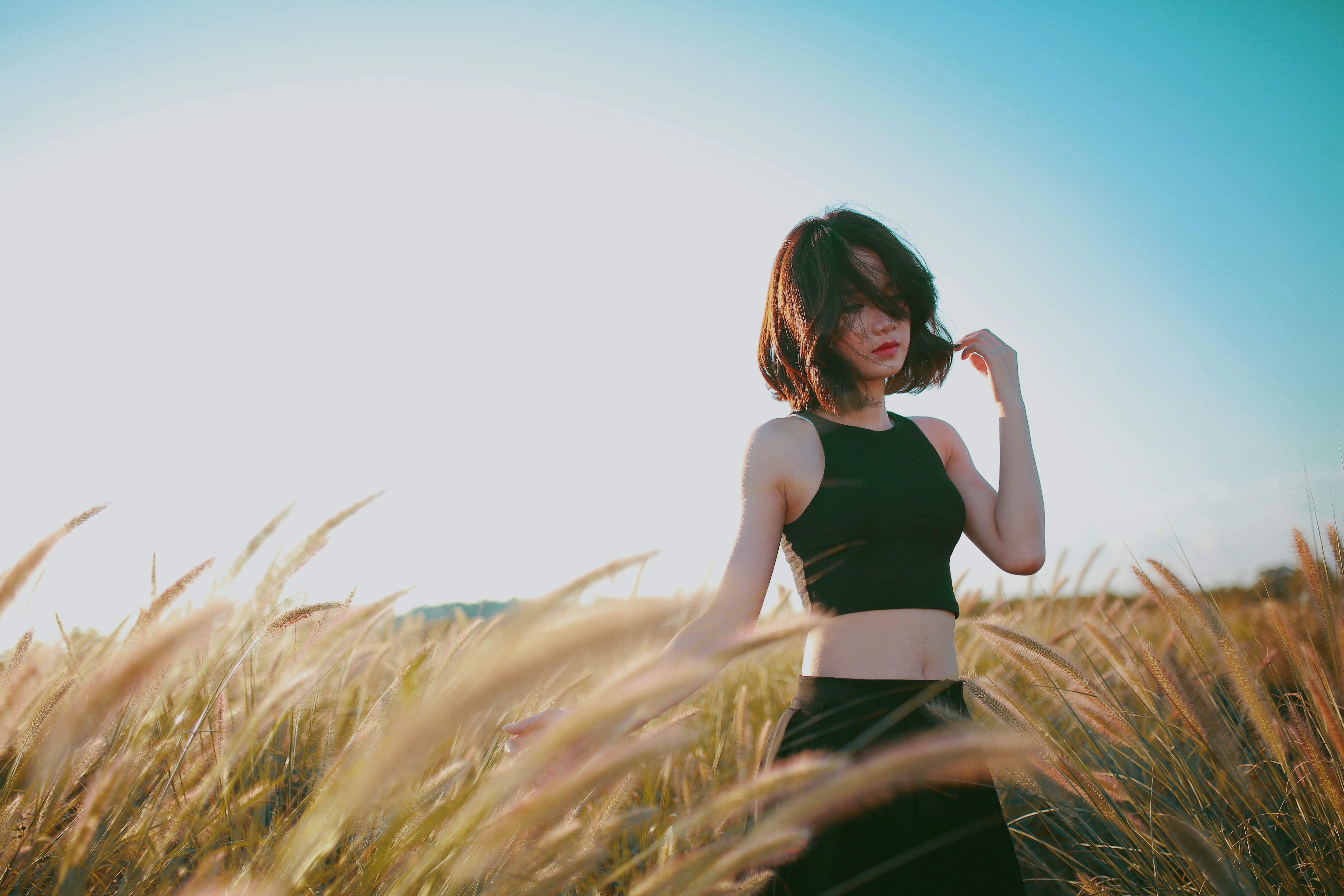 Woman poses in a windy field.