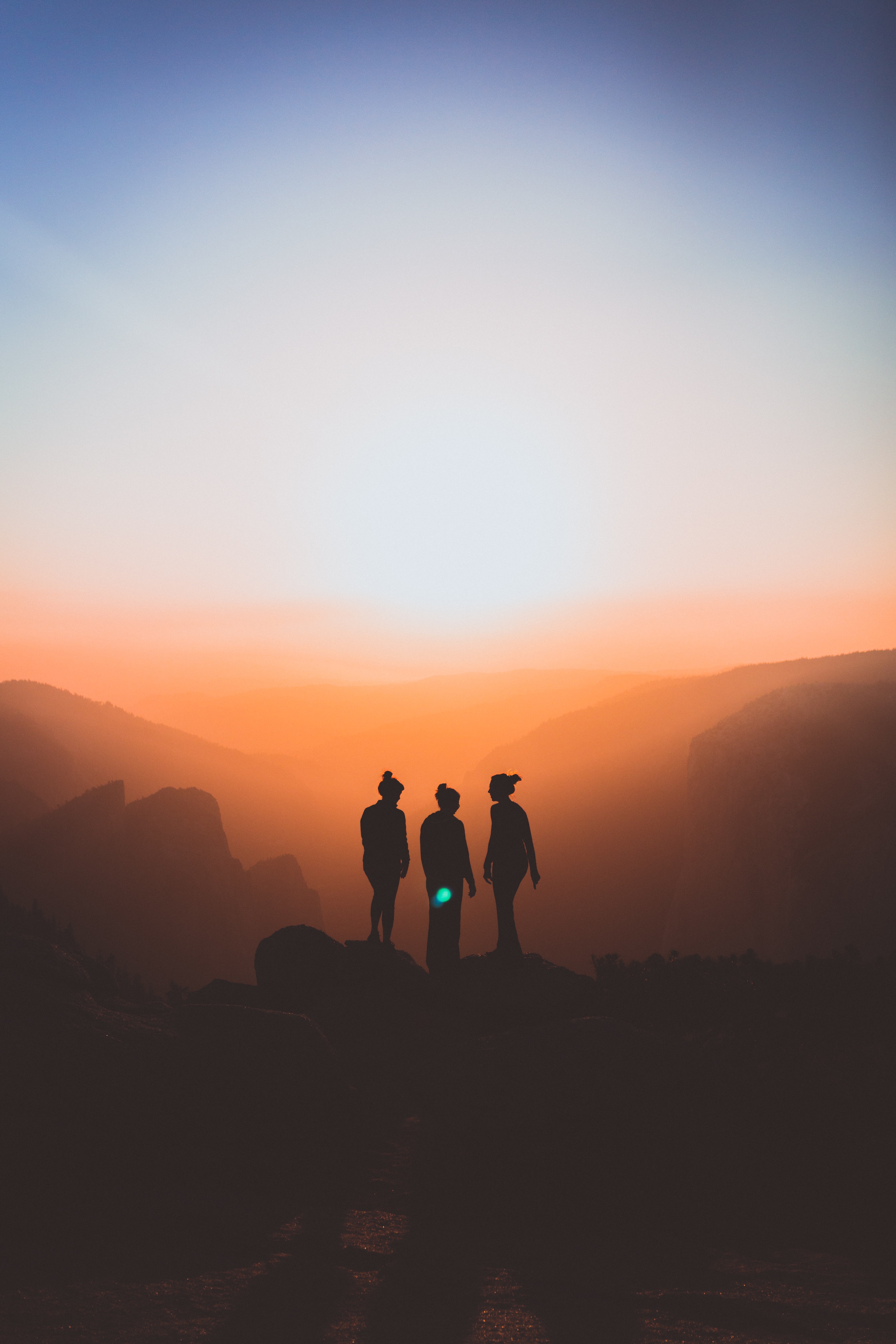 silhouette of three people at sunset