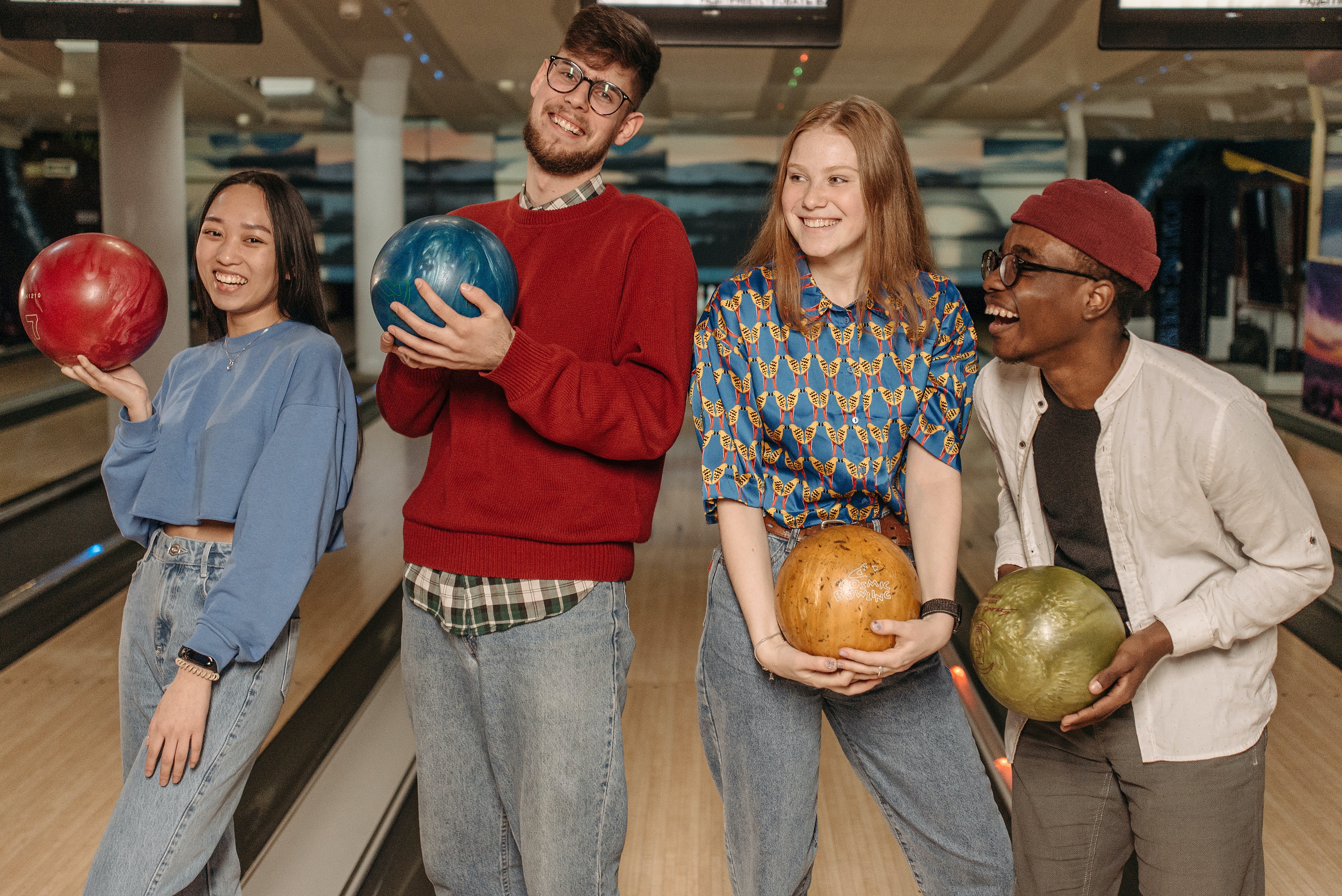 Close-Up Shot of a Group of Friends Holding Bowling Balls