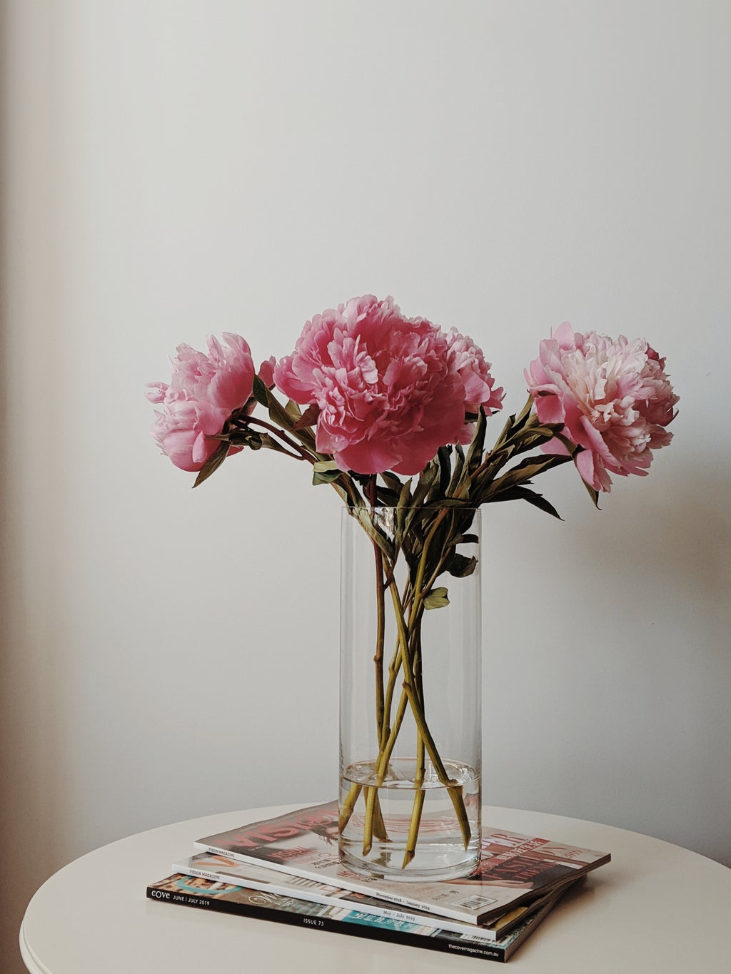 vase of flowers on a stack of magazines