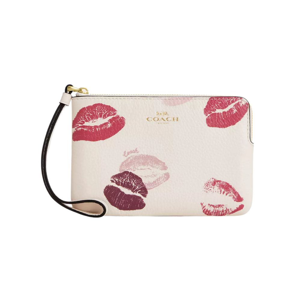 A white wristlet bag with lipstick prints and a leather wrist strap