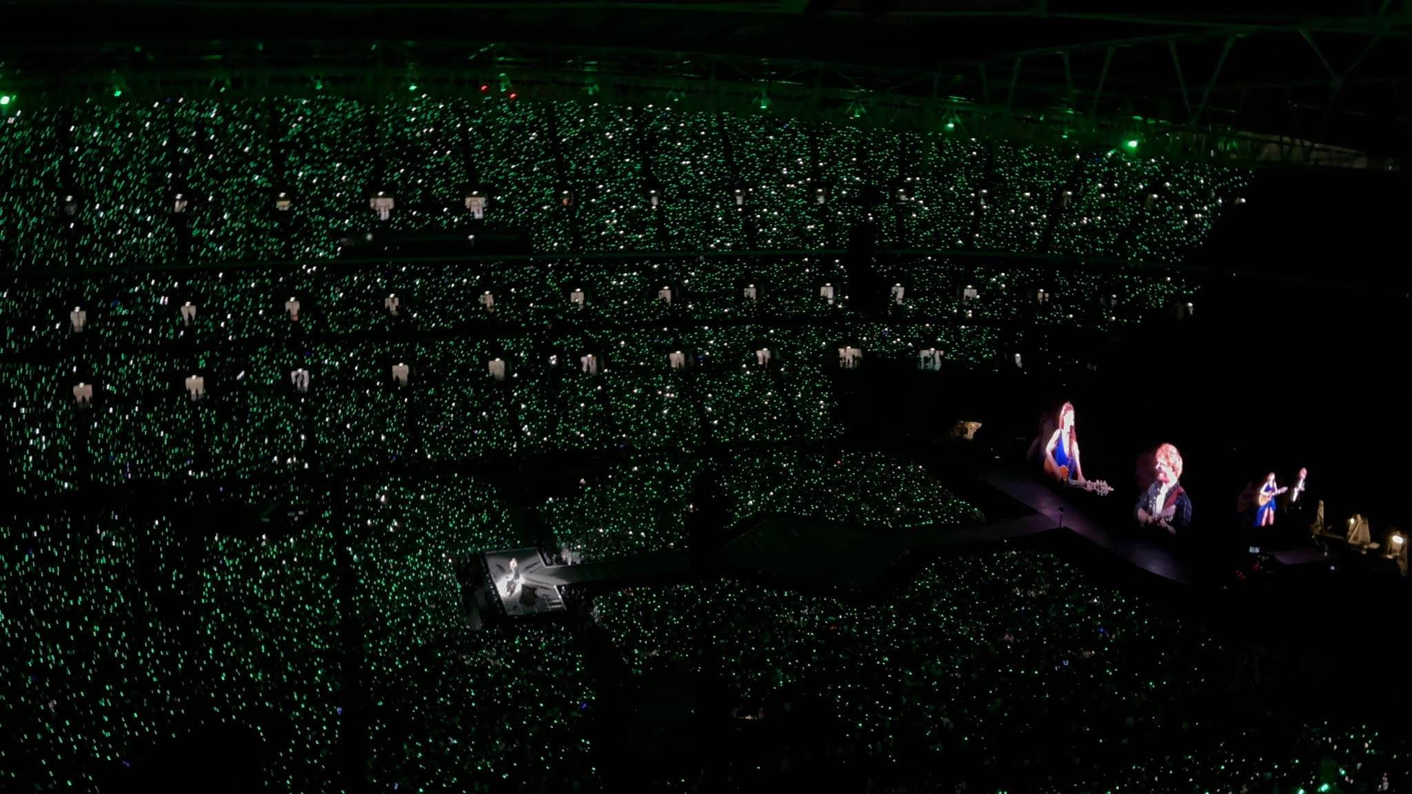 nighttime wide view of taylor swift concert, green lights