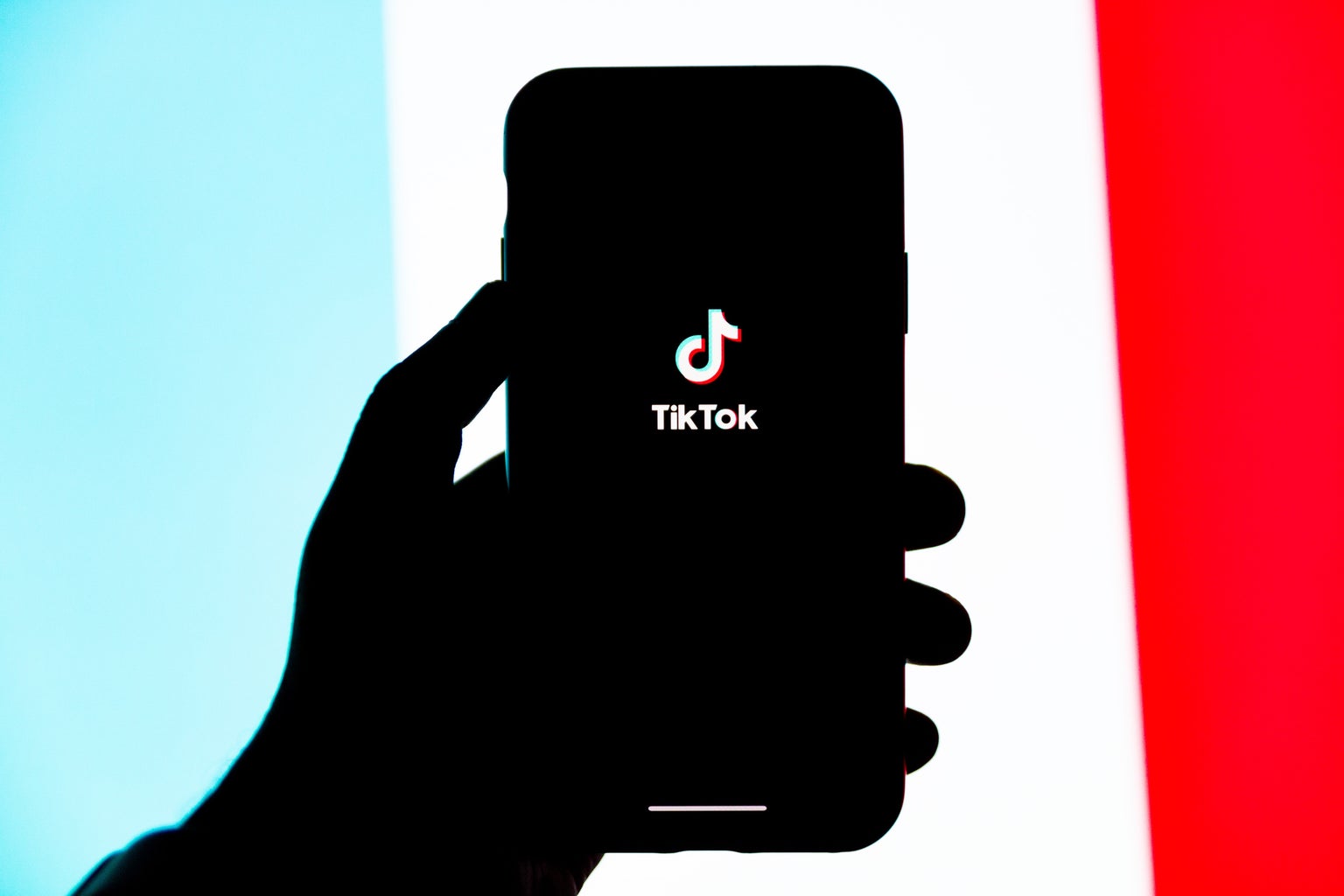 a person\'s hand holding a phone with the tiktok screen open