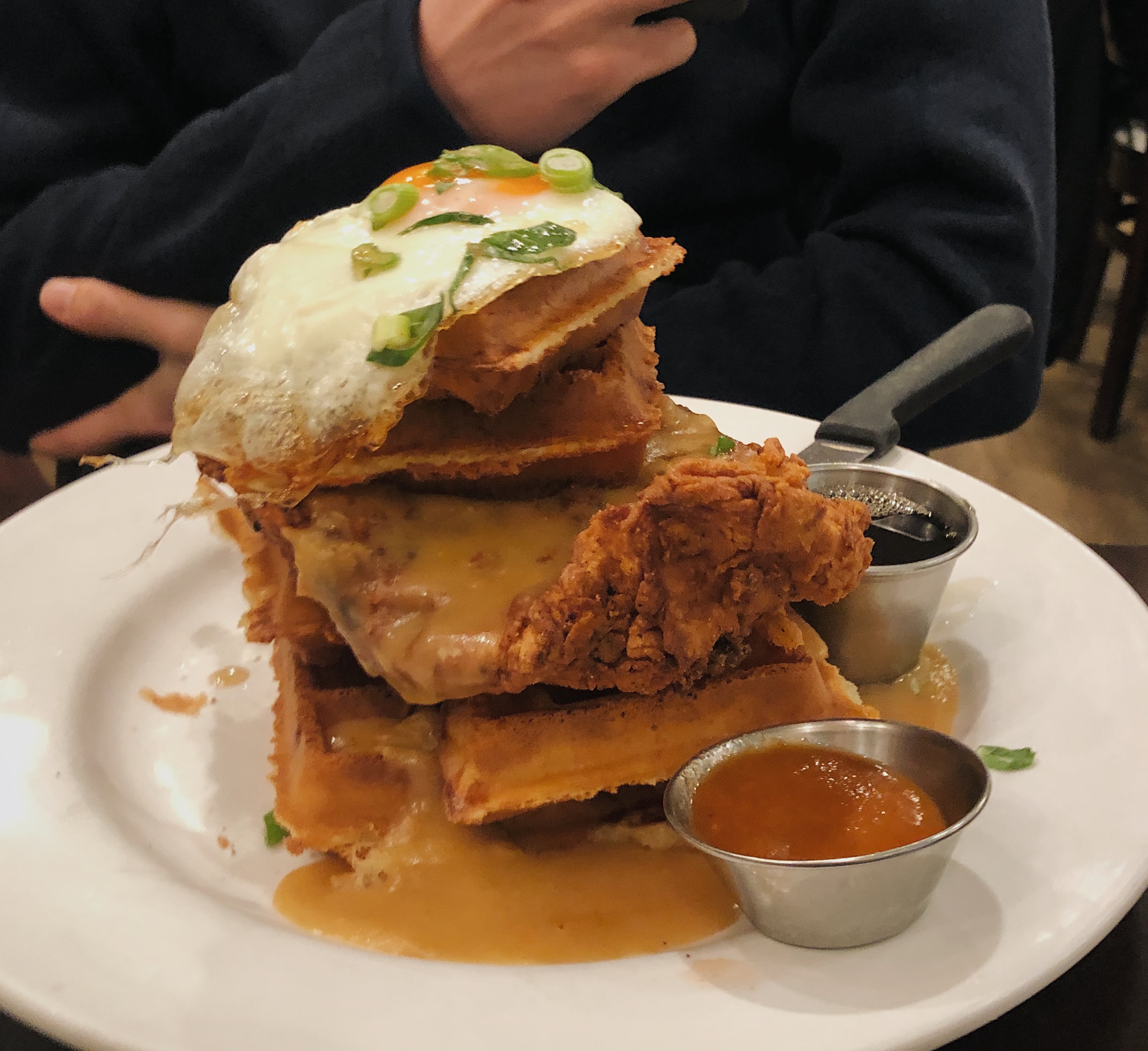 close up photo of fried chicken on waffles on plate