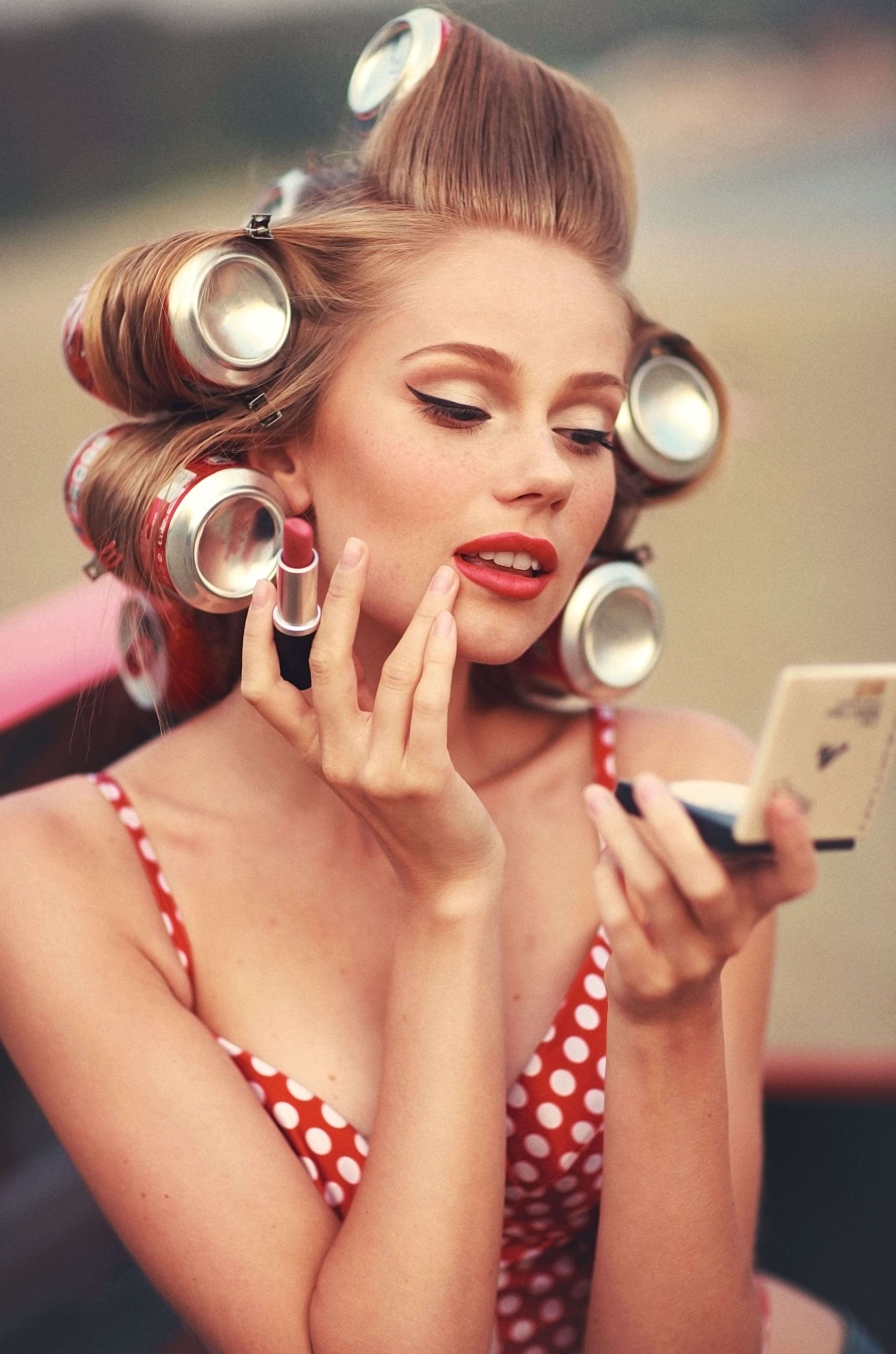 A 1950\'s woman with soda can rollers and polka dots