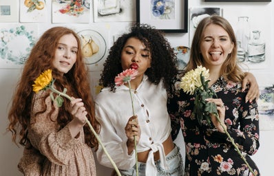 women with flowers smiling and posing
